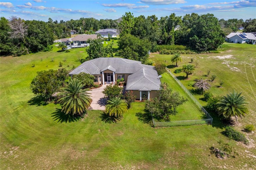 PRICE REDUCED UNDER APPRAISED VALUE!!! Welcome to your piece of paradise including an 8-acre property with cement block construction, stucco exterior, and fresh paint inside and out. Enjoy the spacious 3,020 sq. ft. finished living space with 4 bedrooms, 3 bathrooms in this custom-built home with vaulted ceilings, the master suite with large walk-in closet, en suite bathroom featuring jetted tub and roman-style walk-in shower with two shower heads is sure to please. On the other side of the split floorplan, you will find 2 bedrooms with shared Jack & Jill bathroom and pocket doors (standard closets). Additional large bedroom with standard closet and full bathroom across the hall (also serves guests), formal dining room off the living room. This is a pet friendly layout with dog door from kitchen to screened lanai and from lanai to covered patio with exterior ceiling fan. A large 3-car garage (825 sq. ft.) with attached laundry room awaits your vehicles and/or toys with plenty of additional storage. 
Outdoor features include screened-in back lanai and screened-in front vestibule large fenced yard encompassing rear and side of home (approx. 1 acre irrigated with six zones), water fountain in backyard with continuous fresh water supply and electricity, seven mature palm trees and mature gardenias, organic blueberry hedge (approx. 120 sq. ft.), fruit trees: 3 young Plouhari trees (plum-cherry hybrid, fruiting in early spring), 2 young apple trees (not yet fruiting).
Previously operated as a plant nursery - extensive underground irrigation remains, with four water spigot locations, 2,400 sq. ft. metal building with concrete floor, electric, and plumbing (ideal as workshop, office, or storage), large chicken coop (16' x 8' x 8') with fenced run, automatic sunrise/sunset door, and water supply. - Mature live oaks, cleared and maintained grass throughout and a private driveway to property make this a MUST see!
ADDITIONAL OPTIONS
- Adjacent 0.37-acre lot available for purchase, providing additional residential access point for improved ingress/egress
- Option to purchase farm equipment, including:
- Yanmar diesel 40-horsepower tractor, finish mower deck, one plow, disc for disking the field, rake for raking the field