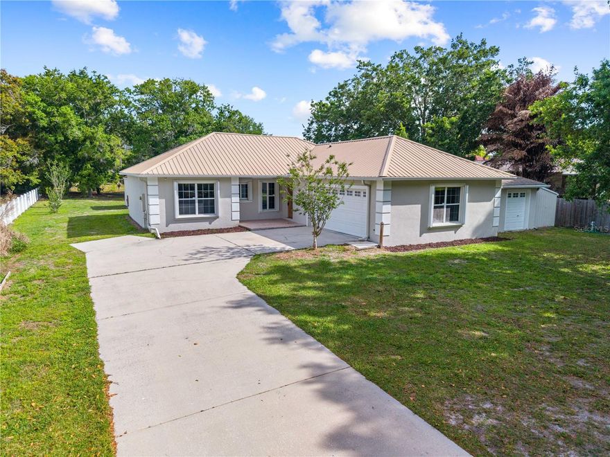 One or more photo(s) has been virtually staged. Fully RENOVATED and thoughtfully upgraded, this Beautiful St. Cloud property offers a clean, modern interior paired with major structural and efficiency improvements that are hard to find, all set on just OVER AN ACRE OF LAND. The kitchen has been completely redone with new cabinetry, QUARTZ countertops, updated NEW appliances, and sleek fixtures, all complemented by fresh interior lighting and ceiling fans that carry a bright, cohesive feel throughout the home. Interior and exterior paint have both been redone, giving the property a crisp, move in ready presentation from the moment you arrive. CERAMIC TILE flooring runs throughout the home, adding durability and a seamless look from room to room. Beyond the cosmetic upgrades, the home is equipped with a whole house Generac GENERATOR, HURRICANE SHUTTERS for added protection, and DOUBLE INSULATION for improved energy efficiency and comfort. A durable METAL ROOF  adds long term value and peace of mind. In addition to the oversized two car garage, the property includes two spacious sheds, one tucked out back and one off to the side, providing practical, usable space for storage, equipment, or projects. This is a property that delivers both thoughtful upgrades and the kind of functionality that truly supports everyday living. Come check out your new home today!!