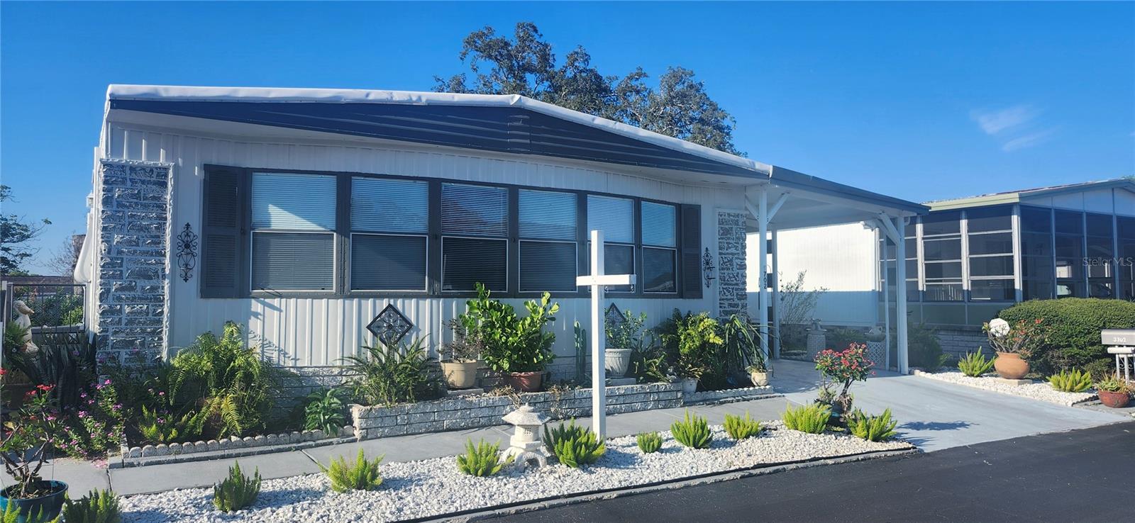 Very nicely updated 3 bed/2 bath doublewide with large storage room (3rd bedroom option), shed, carport, and screened porch in Tiki Village, a gated 55+ community where you own the land. NON-FLOOD ZONE with low $520/year HOA. Updates include new roof and A/C (Sept 2024), spacious new kitchen with granite countertops and new appliances, remodeled bathrooms including a master bathroom with jetted tub, new vinyl flooring, new interior/exterior paint. Home shows very well. PRIDE.