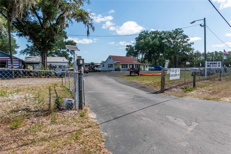 This is the perfect place to live AND work, all in one property!  Resting on 1.65 acres, this property is Zoned B-3 and provides roughly 360 ft of highly visible road frontage along busy W. Highway 40, making this a great opportunity for a variety of businesses.  Currently used as a consignment business, office and primary residence, the property features a circular drive with two gated entrances and perimeter fencing.  Two buildings rest on the property, a 2 bedroom, 1 ½ bathroom home with 1,865 sq.ft. of living space and an additional 960 sq.ft. concrete block workshop/garage area.  Uniquely appointed and updated, the home sits at the apex of a circular driveway and includes a carport and ramp entry at the back for additional accessibility.  The interior offers beautiful wood accents, ceiling fans in each room, a living/dining or meeting room which provides easy access to the charming country kitchen and a family room.  A glass enclosed front lanai features wood-finished ceilings and lots of light, which currently serves as additional office space.  An integrated 306 sq.ft. bonus space offers separate front entry, making this a wonderful option for an at-home office/business space or studio.  Separate from the home is the spacious workshop/2 bay garage with metal roof, which includes power and two internal spaces for storage or office area.  A second carport and covered areas attached to this building provide additional workspace as needed.  There is plenty of space to park RV’s, with existing 30 and 50 amp hook-ups on property, boats and more.  Within close proximity to all Dunnellon has to offer, the Rainbow River, Rainbow Springs State Park, the Goethe State Forest and the Withlacoochee Trail, making this a wonderful option for those looking to enjoy the natural side of Central Florida.  If you’re searching for the perfect place to run your business right from home, this unique property is a wonderful option to consider.