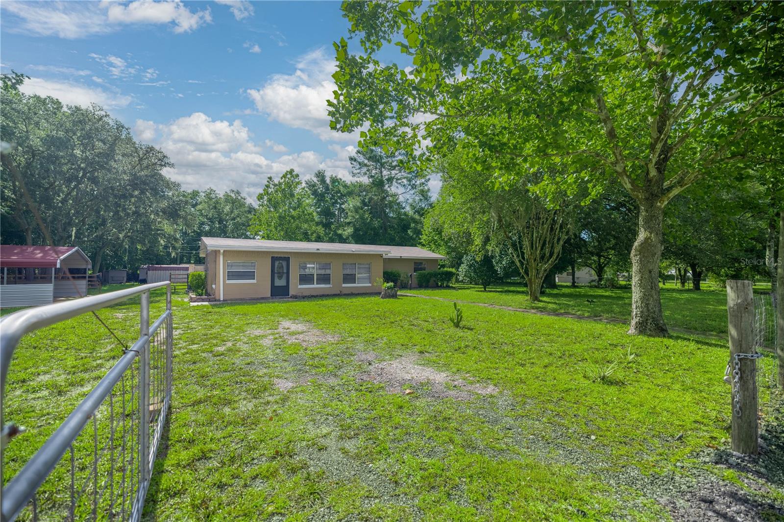 If you're searching for privacy, space, and modern upgrades, this beautifully refreshed 3-bedroom, 1.5-bath home in a serene country setting checks every box. Nestled on a fully fenced 1.07-acre lot at the end of a quiet paved dead-end street, this property offers both seclusion and convenience. Inside, the home has been thoughtfully renovated with easy-to-maintain flooring throughout (no carpet), fresh interior and exterior paint, and stylishly updated bathrooms. The spacious eat-in kitchen features all-new top-of-the-line GE appliances, a sleek backsplash, and brand-new cabinetry. A dedicated home office with its own private entrance is ideal for working from home or meeting clients. Outside, the fully fenced yard provides privacy and peace of mind, with a gated entrance, a newly installed two-car carport, and three versatile outbuildings. One of the outbuildings is already equipped with electric and ready to function as a workshop. The backyard includes a newly finished outdoor area, perfect for grilling, entertaining, or simply enjoying the open space. Major upgrades include a new roof (2023), new AC (2024), new septic and drain field (2020), a new well water tank, and all new fixtures including blinds, ceiling fans, locks, and more. With its quiet setting and easy access to Chiefland, Newberry, Williston, Gainesville, and Ocala, this property offers the perfect combination of move-in-ready comfort, privacy, and modern country living.