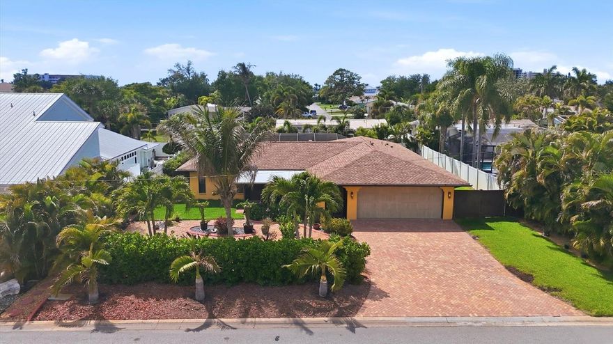 Tucked away on a quiet, private double cul-de-sac on Venice Island, is a very special home within walking distance of the Gulf, as well as downtown with all of its activities! This beautiful home, pool, pool cage, and yard, has been totally renovated within the last 6 years. The spacious screened patio off the front entrance has sunrise sky views as well as a great place for coffee in the morning or a glass of wine with friends when the day is done. The front patio overlooks a professionally landscaped, low maintenance front yard, including a fruit bearing coconut tree, and is wrapped in privacy from the street. Leaving the front door & windows open to the screened front patio, and the 2 sliding glass doors to the lanai, gives you wonderful breezes throughout the home! Walking into the home, the dramatic oversized waterfall edge kitchen island commands your attention, with plenty of entertainment space in the living area as well. The kitchen cabinets are sleek and contemporary with abundant storage. There is a designated coffee bar as well as a wine cooler tucked out of sight, so you always have enough of both! The dining area features custom wood beams on the ceiling and contemporary lighting. Master suite is gracious, including a steam room shower, large walk-in closet and a private door to the lanai and pool. The pool surround was enlarged for relaxing & entertaining, the lanai curtains soften the setting sun, and a convenient pool shower is available for your after-beach excursions. All four pool decks and lounge chairs remain with the home so nothing can stop you from a little R&R while you unpack! A private well supplies irrigation all year, and a whole house filtration system insures healthy water for you. Two of the three bathrooms are ensuite, convenient for guests, a returning student or adult child. The yard is landscaped with paths, mature plants, and is fenced for privacy and pets. The 2-car garage has epoxy flooring and the floor to ceiling cabinets are there so all your storage is out of sight! Sitting on higher ground than the surrounding area, it has not suffered damage from the last few hurricanes. With all the recent updates, this home should give its new buyers years of low maintenance and lots of enjoyment! Don't miss this one!