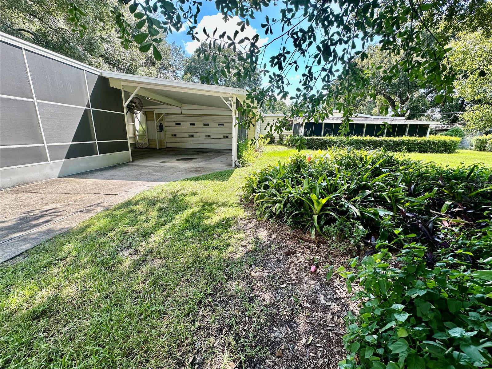 Discover the potential in this Winter Haven property located just minutes from the Polk Parkway. Situated on a spacious .27 acre lot, this single-wide M.H. with an addition offers plenty of room inside and out. The yard features lush mature trees and shrubs, providing both shade and privacy. Enjoy the outdoors year-round from the 14X30 screened in front porch. A large detached workshop/garage offers storage and project space, while the oversized carport easily accommodates a boat, extra vehicles, or outdoor toys.
The home itself could use some TLC, making it an ideal opportunity for those looking to add value with updates and personal touches. Whether you're seeking a primary residence or a investment this property has great potential!