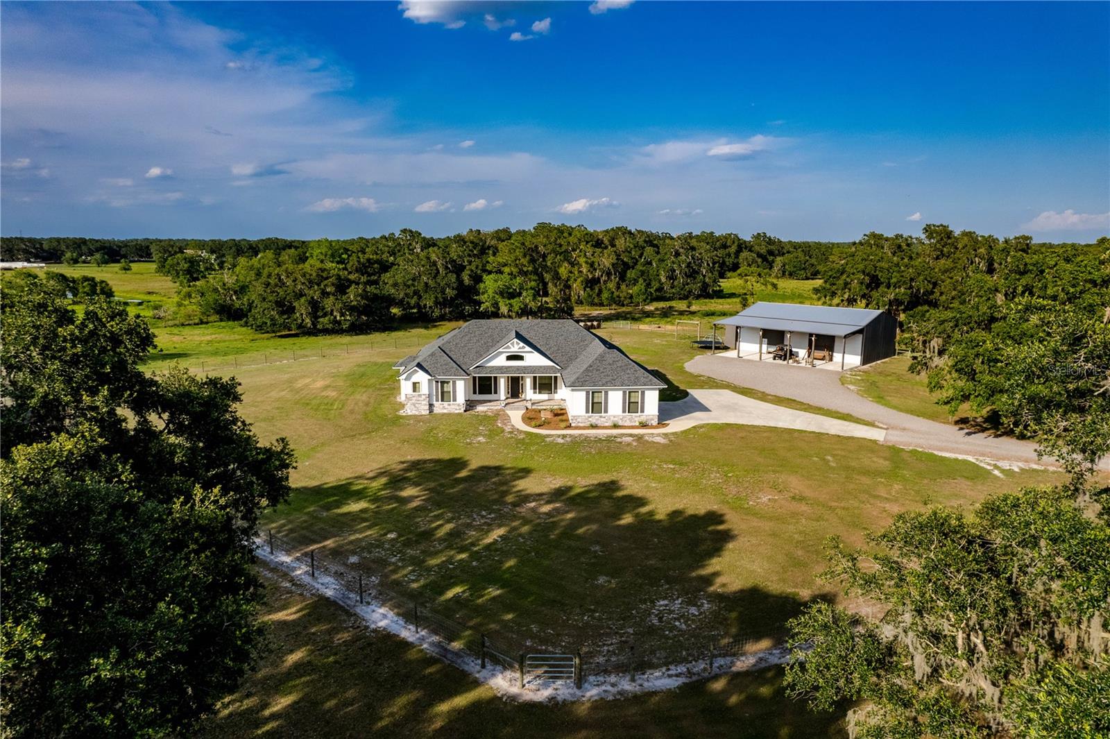 Tucked just off County Line Road in Lakeland, Florida, this 140± acre ranch embodies the essence of a true working homestead—rich in history, thoughtfully improved, and ready for continued agricultural use. Comprised of three contiguous parcels and just minutes from I-4 (Exit 25), this property offers both a practical location and the timeless beauty of old Florida land.
This ranch has served generations—raising cattle, cultivating memories, and standing as a testament to the grit and grace of rural life. Towering oaks provide shade over improved pastures and cross-fenced for rotational grazing. Native palms, meandering creeks, and strong grasses create an ideal landscape for grazing and sustainability.
At the heart of the property sits a custom-built Ernie White pool home with nearly 4,000 sq ft of living space. With 4 bedrooms, 3 bathrooms, and an office, this home is a blend of style and function. High-end features include level 4 quartz countertops, soft-close black wood cabinetry, top-of-the-line stainless appliances, and a massive island designed for family and farm gatherings. The wide-plank tile flooring, 10-foot wood-beamed ceilings, and impact-rated windows speak to the quality and durability built into every detail. The exterior features Hardie Board and stone siding, upgraded insulation, gas utilities, and a whole-home generator for peace of mind. Outdoors, a saltwater pool and summer kitchen area make for the perfect end to a hard day’s work.
Supporting the operational needs of the land, a 60x40 metal barn with a 20x60 lean-to is plumbed for a full bathroom and includes power, water, a 12x12 well room, 6” slab, three oversized bay doors, and a 50-amp RV hookup. Additionally, a 30x40 pole barn offers further equipment or feed storage, ready for your tractors, trailers, or hay.
While the land is perfect for active ranching today, its potential tomorrow is equally exciting. The property holds a future land use designation for residential, and the front 20 acres, located just yards from the high-growth commercial and industrial corridors of Swindell and County Line Rd, could offer substantial long-term value for the right investor.
Whether you’re looking to expand an existing ag operation, create a family legacy homestead, or secure a land asset with serious future upside, this Lakeland ranch offers it all—function, beauty, and promise.