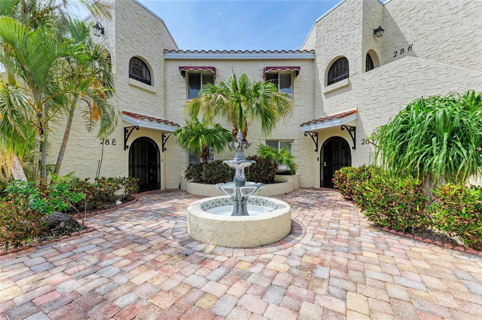 Experience a seamless blend of Spanish-style architecture and relaxed Florida living in this polished 1st floor, 2-bedroom, 2-bath condo located in the desirable Vizcaya gated condo community of Bradenton.
Make your way into the paver courtyard entryway, highlighted by a decorative fountain, and step inside a spacious, light-filled home featuring a neutral color palette and light tile flooring throughout the main living areas. The carpeted bedrooms add warmth and comfort, while the open-concept living and dining area offers a versatile space for relaxation and entertaining.
The expansive European-style kitchen is complete with newer stainless steel appliances, two closet pantries for ample storage, an optional second dining area, and a convenient pass-through window to the main dining area.
Unwind in the large primary bedroom suite with a walk-in closet, en suite bathroom, and private access to the glass-enclosed Florida room. The en suite bathroom features a double-sink vanity, soaking tub with shower, and a sliding glass door leading to the private rear patio. The second bedroom is equally inviting, offering plush carpeting, a ceiling fan for added comfort, and its own patio access.
Spanning the entire length of the home, the Florida room boasts tile flooring and floor-to-ceiling glass walls, with sliding door access from the living room and primary bedroom—perfect for enjoying the Florida sunshine in air conditioned comfort. The adjacent rear patio is partially covered for both sun and shade, and is enclosed by a tall privacy wall for quiet relaxation.
Viscaya offers resort-style living with tropical landscaping, four scenic lakes, and amenities that include a recently remodeled clubhouse with a party room, dance floor, HDTV, modern kitchen, sauna-equipped bathrooms, an exercise room, card room, library, pool table lounge, and a spacious deck surrounding a heated Olympic-sized pool and spa. An active social committee hosts a variety of events for residents, including exercise classes, card games, bingo, yoga, dinners, dances, and more—making it easy to stay connected and enjoy the vibrant community atmosphere.
Conveniently located near IMG Academy, downtown Sarasota and Bradenton, and world-renowned beaches on Anna Maria Island, Longboat Key, and Siesta Key. Nearby shopping, dining, golf, art and theater venues, museums, and medical centers make this the ideal place to live and play.
Don’t miss your chance to own a piece of paradise in one of the area’s most desirable communities!