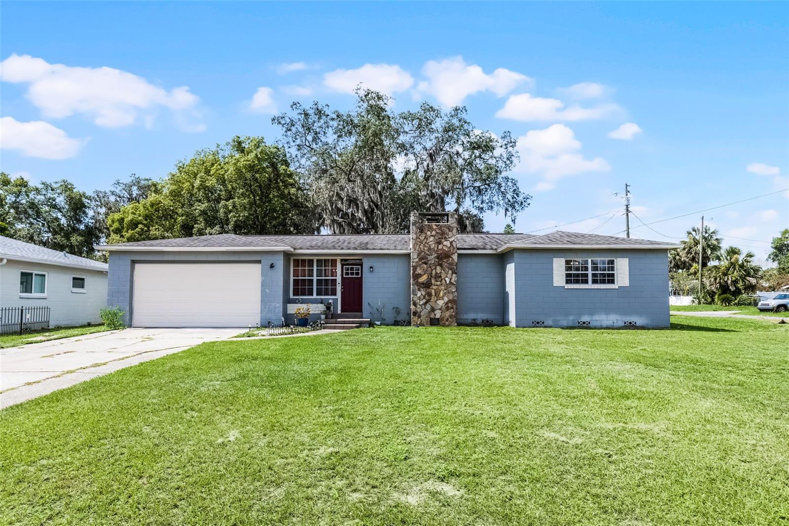 Welcome home to this charming concrete block 3-bedroom, 2-bath home, perfectly positioned on an oversized corner lot just a short walk from vibrant downtown Eustis. Move-in ready with key updates, including a newer architectural shingle roof (2018), updated windows (2008), and a renovated bathroom. The light-filled kitchen features granite countertops, stainless steel appliances, and a new refrigerator (2020).
Enjoy beautiful hardwood and tile flooring throughout—no carpet—plus vintage built-ins and a cozy fireplace that adds timeless character.
The oversized garage with a utility room provides plenty of extra storage space. Don’t miss this opportunity—schedule your tour today!