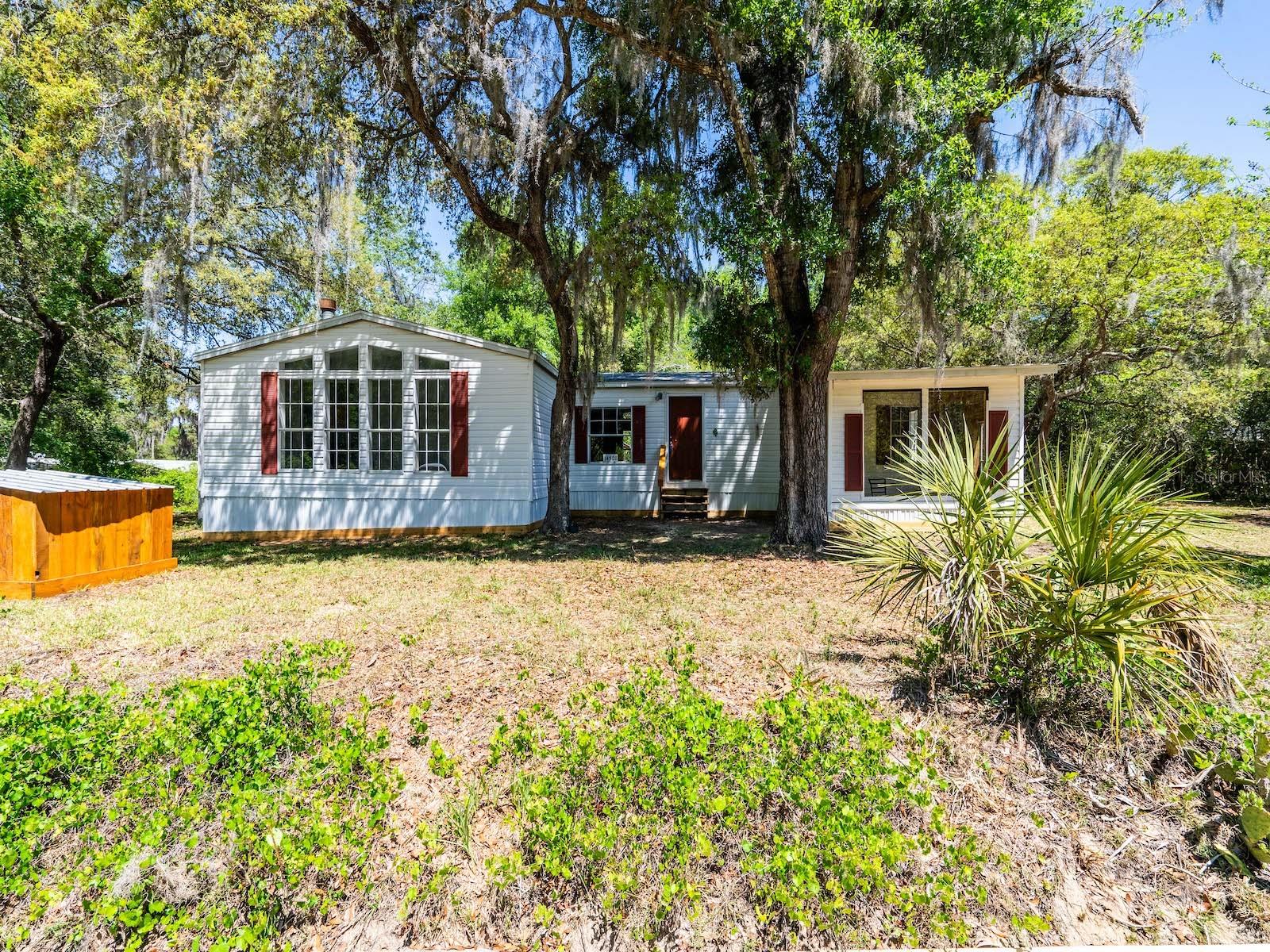Quiet Country Living Across from Ocala National Forest – Fully Updated & Move-In Ready!
Welcome to your peaceful retreat nestled on an oversized 0.41-acre lot (200’ x 90’) with privacy, no HOA and only one nearby neighbor, this beautifully remodeled retreat is located on a dead-end street for ultimate privacy and peace. Directly across from the Ocala National Forest and OHV trails – perfect for off-road adventurers, nature lovers, and anyone craving quiet country living!
This beautiful 1995 manufactured home offers 2,108 sq ft of living space, 3 spacious bedrooms, 2 full bathrooms, and is situated on a short dirt road with just one nearby neighbor – providing the perfect blend of seclusion and accessibility. Offers a spacious storage shed in the backyard. As you arrive, you’ll be drawn in by the charm and tranquility of the setting, complete with a 150 sq ft screened-in porch, ideal for sipping your morning coffee, listening to birdsong, or winding down after a day of adventuring. Step inside and you’re greeted by a warm, welcoming foyer that flows into an expansive living room and formal dining area. The adjacent family room features a custom star wood accent wall and cozy wood-burning fireplace, creating the perfect atmosphere for entertaining or quiet nights in.
The fully remodeled kitchen is a chef’s dream with:
- All-new soft-close plywood cabinetry
- Stylish formica countertops with wood trim
- Island with lunch bar and plenty of counter space for preparing your favorite dishes
- Durable LVP flooring, new 2025
- Stainless steel appliances including a range, refrigerator, and dishwasher
- Garbage disposal
- Large pantry, eat-in breakfast nook, and access to the indoor laundry room with a built in folding counter and cabinet
The oversized primary suite is truly a retreat, offering:
- His and hers walk-in closets
- An oversized en-suite bathroom with garden tub, double his/her sinks, and separate shower
The two guest bedrooms are generously sized with walk-in closets, and a full second bathroom with tub/shower combo and updated LVP flooring.
Extensive upgrades make this home truly move-in ready:
- 2020: New HVAC and ductwork (2023)
- 2024: Brand-new roof (November 2024)
2025:
- Fully remodeled kitchen
- New stainless steel appliances
- New EX plumbing throughout
- All new outlets, switches, and modern light fixtures
- New LVP and carpet flooring
- Fresh interior paint
- Updated exterior skirting
- 4” well (110’ deep) with a new tank and water line, and high-speed internet.
Outdoor enthusiasts will love the location:
Just minutes from boat ramps, the Ocklawaha River, Rodman Reservoir, and some of Florida’s most beautiful natural springs, including Salt Springs, Juniper Springs, and Silver Glen. Whether you enjoy fishing, kayaking, hunting, hiking, or horseback riding, the area offers endless recreation opportunities.
Conveniently located just:
- 8 minutes from a Dollar General Grocery store
- 15 minutes from Fort McCoy – grocery, pharmacy, gas, hardware, and local dining
- 25 minutes from Silver Springs – Walmart, Lowe’s, Bealls, and restaurants
- 35 minutes from Ocala – nightlife, shopping, and entertainment
- 50 minutes to Gainesville – Home of the Florida Gators
This one-of-a-kind home offers the perfect blend of modern updates, privacy, and access to Florida’s outdoor playground. Whether you're looking for a full-time residence, weekend getaway, or your own private oasis—this home has it all.