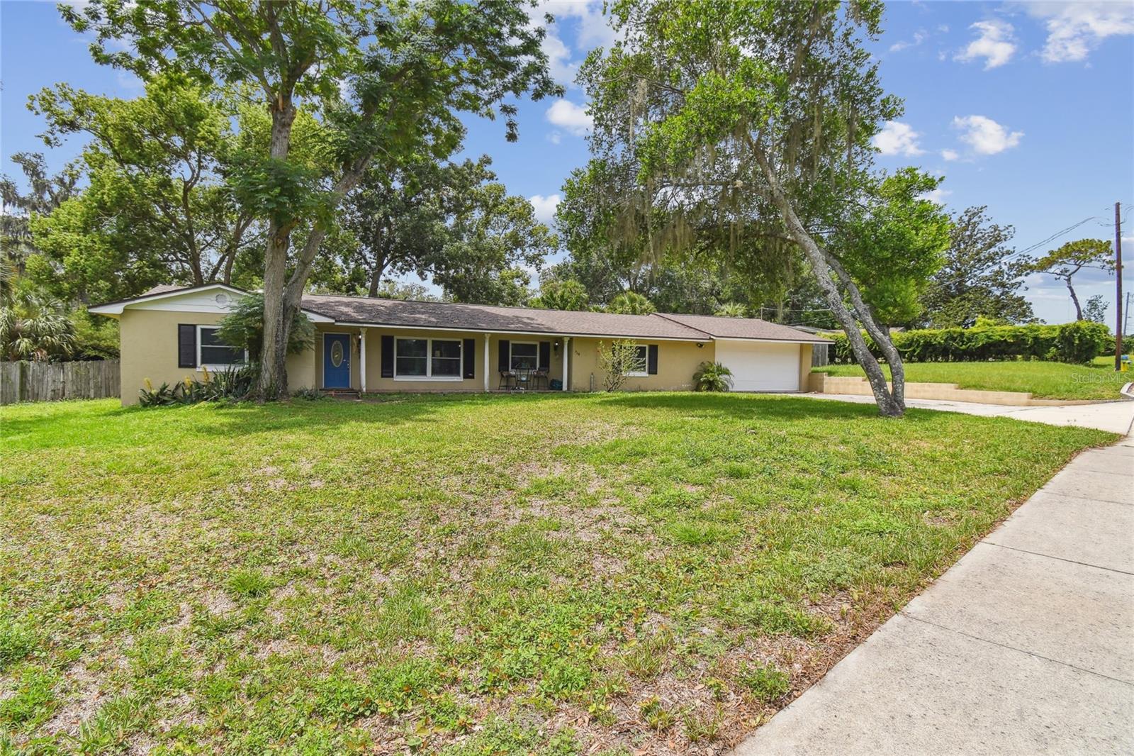 HIDDEN HAVEN ON A HALF ACRE LOT - If your dream includes a peaceful Florida lakeview lifestyle—tucked away like a secret garden, yet just minutes from the bustle of city life—this rare gem in Altamonte Springs is calling. Just a few lanes away from city life, a tree-canopied street, framed by bougainvilleas and mature foliage, leads you into the tranquil Sanlando community. As glimpses of the lake appear through the trees across the street, the sounds of traffic fade and a sense of peace takes over. Inside, the open-concept layout welcomes you with warm luxury vinyl plank flooring, natural light streaming through DOUBLE-PANED WINDOWS, and soft transitions between living, family, dining, and kitchen spaces. Whether you're hosting a lively gathering or enjoying an intimate meal, the floor plan offers both flow and function. Culinary artists will find this kitchen a delight to cook in, as it features granite countertops, sparkling stainless steel appliances, pendant lighting, and a large breakfast bar—the heart of the home for scrumptious creations or delicious coffee that can begin in the mornings and continue for golden hour chats. To the right, the private primary suite is a true retreat with details of crown molding, a large 6' x 11' walk-in closet, and a peaceful ensuite bathroom. For privacy, on the opposite side of this SPLIT-BEDROOM FLOORPLAN home, you will find two additional bedrooms—one with an ensuite half bath—are paired with a full shared bathroom for comfort and flexibility. Behind the kitchen, a versatile bonus space lends itself to a walk-through pantry or what could be used as an additional storage area. This connects to a spacious indoor laundry room and a second flex room that opens into a 14' x 18' workshop—a dream for hobbyists, crafters, and creators alike. Whether you're building, tinkering, or dreaming big, this space is ready to grow with you and indeed a rare find. With NO HOA in the Sanlando community, you have the freedom to live your way, so store a boat, RV, any other adventure gear you may have. The FULLY FENCED BACKYARD, is a blank canvas to design your dream outdoor space like a garden, pool, playground – the possibilities are endless and when you’re not busy, unwind on the screen-enclosed patio off the kitchen. Whether you're grilling, hosting, or simply sipping something cold in solitude, this hidden sanctuary feels like a world of its own. Quietly nestled near I-4, major shopping, dining, and entertainment, this move-in ready retreat offers serenity without sacrificing convenience. In addition to the newer windows, the roof was replaced in 2020, AC in 2014, and most of the electrical and plumbing have been updated at some point, so you should have most of the ‘big ticket expenses’ already taken care of. DON’T WAIT, MAKE THIS YOUR NEW HOME TODAY!