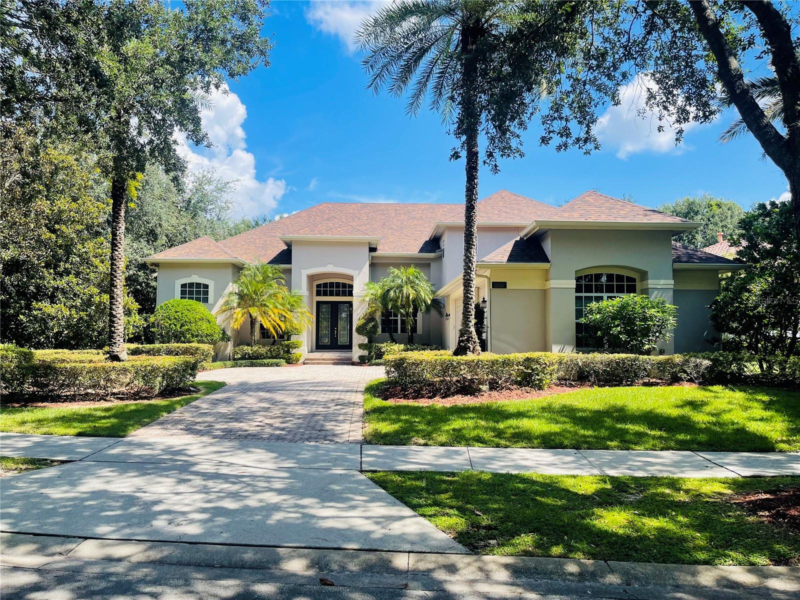 Ideally situated on a corner lot within the prestigious, 24-hour guard-gated community of Keene’s Pointe in Windermere, this residence offers the perfect blend of elegance and comfort. Keene’s Pointe is renowned for its exceptional amenities, including fitness facilities, swimming, tennis, golf, and dining, all while being just minutes from Disney, shopping, and fine restaurants.
The home welcomes you with a beautifully maintained brick-paved driveway, lush landscaping, and a spacious three-car garage. Step inside to an open floor plan filled with natural light, soaring vaulted ceilings, modern light fixtures, and upscale finishes throughout.
The first-floor primary suite features a tray ceiling, luxury waterproof vinyl flooring, and a generous walk-in closet. A versatile office/bonus room is also conveniently located on the main level. The gourmet kitchen is a chef’s dream, offering custom cabinetry, quartz countertops, natural gas, and a double built-in oven.
Upstairs, you’ll find two additional bedrooms and a full bathroom. The private backyard is designed for relaxation and entertainment, with a heated pool and spa set against a grassy backdrop. Fresh interior paint completes this move-in-ready home.