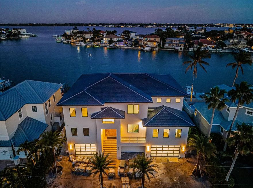 THE FIRST BRAND NEW CONSTRUCTION (NEVER LIVED IN) WATERFRONT HOME AVAILABLE FOR SALE IN BELLEAIR BEACH IN 7 YEARS!  Welcome to the lap of waterfront luxury.  Three floors of steel-reinforced concrete construction and a striking designer-concrete tile roof, support the brilliant amenities and inspiring finishes of this stunning coastal contemporary estate.  Tall 11ft-high ceilings, posh wide-plank wood flooring, spectacular commercial-grade all-glass railings, radiant Fine Art Handcrafted lighting, Euro-style frameless cabinetry, and an incredible custom open floorplan deliver an unforgettable living experience.  Hand-forged steel double door entry opens to dazzling views of your beautiful waterfront. Soaring 25ft-high living room transitions to a wide, luxurious covered balcony with sweeping open water views.  Sumptuous gourmet kitchen features true quartzite counters, Wolf double gas range, Sub-Zero refrigeration, Thermador wine column, Waterstone faucets, a gleaming island bar, and an exceptional butler’s pantry with superb, separate appliances.  Waterfront dining area provides kitchen-matching built-in buffet.  Grand upper-level family room introduces the lavish owner’s suite with commanding views of the waterfront and private access to a gorgeous 24ft-wide covered waterfront balcony.  The posh, pampering owner’s bath is adorned in alluring Italian Marble – with exquisite dual vanities, rich stone soaking tub, a scintillating glass-enclosed dual shower, and two large walk-in closets.  2nd bedroom suite overlooks the waterfront; all bedroom suites are huge, with luxuriously-appointed baths and walk-in closets.  Step out back and indulge in the impressive, fully automated pool/spa overlooking the water – a picture perfect paradise.  Elegant laundry rooms on both living levels, 13-car garage parking, natural gas, tankless hot water heating, new dock/seawall for deep-water boating, solid core doors, all glass garage doors, three Bosch inverter A/C systems, Three-stop commercial-grade elevator, advanced internet/media wiring, concrete-paver driveway, extensive landscaping package, and so much more.  Built to exacting standards with high-quality materials and uncompromising attention to detail, this residence will exceed the needs of the most discriminating of buyers.  Short three-minute walk to the private beach, easy 10-minute boat ride to the Gulf.  A rare opportunity in Belleair Beach!  All dimensions are estimates, buyer to verify dimensions.