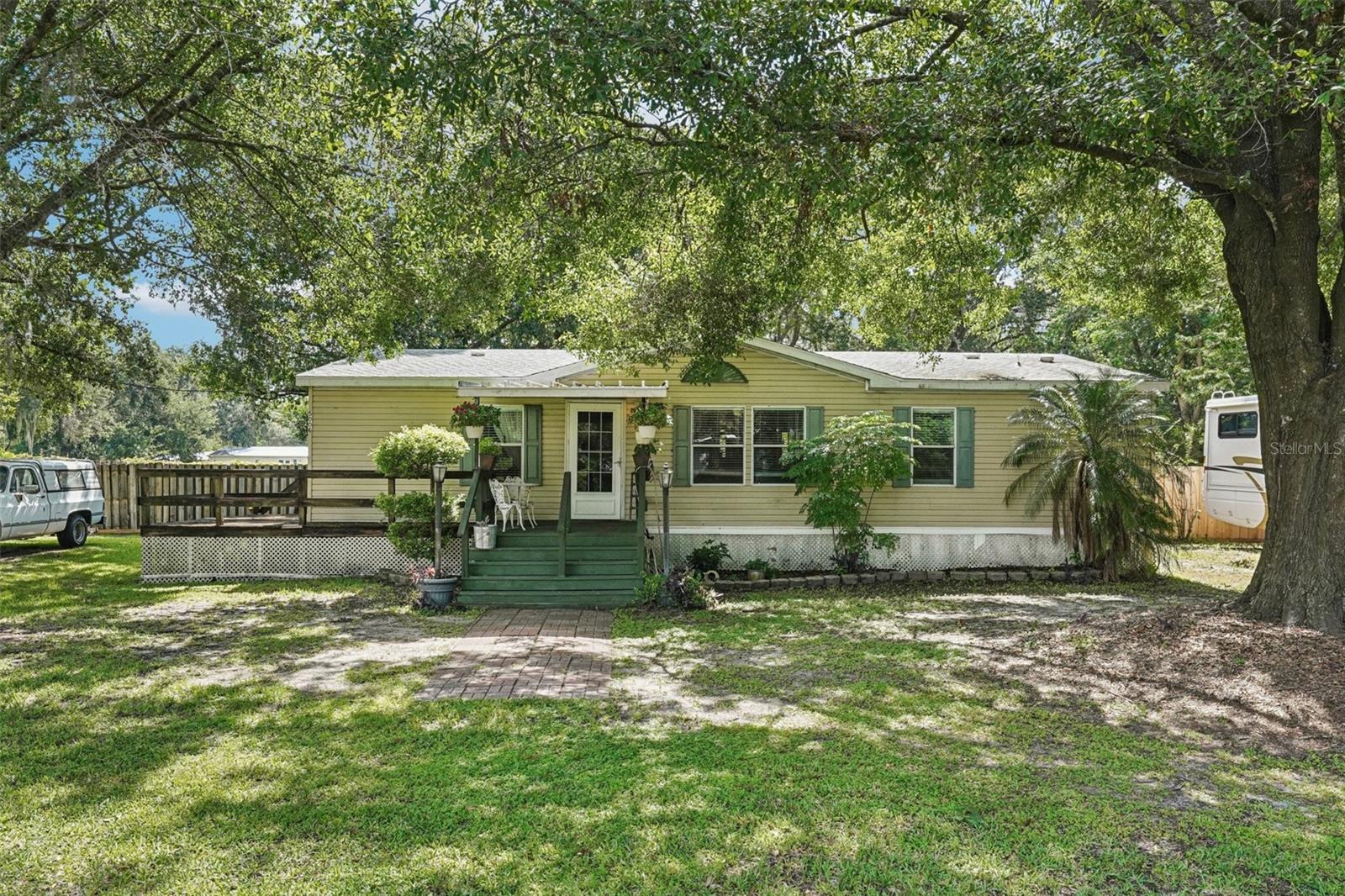 Peaceful Country Living in Plant City – A True Slice of Old Florida Charm!
Welcome to your serene retreat in the heart of Plant City! Tucked away on a beautifully wooded 1.34-acre parcel graced with towering grandfather oaks, this well-maintained 3-bedroom, 2-bath doublewide manufactured home offers the perfect blend of comfort, privacy, and functionality. Whether you're a nature lover, a growing family, or simply seeking a quiet escape from city life, this property checks all the boxes.
With 1,296 square feet of living space, this home boasts a spacious and inviting layout. Inside, you’ll find generously sized bedrooms with oversized closets, two full bathrooms, and an open-concept living and dining area designed for both relaxation and gathering. Natural light pours in, giving the home a warm and welcoming feel throughout. The wraparound wood deck provides the perfect space for morning coffee, evening sunsets, or weekend BBQs with friends and family.
The updated kitchen comes fully equipped with all appliances included, making move-in a breeze. Easy to maintain ceramic tile and hardwood flooring throughout.
Outdoor enthusiasts and DIYers will love the additional features this property has to offer—a charming back porch for relaxing afternoons and a detached workshop/outbuilding that provides ample space for tools, projects, or storage. Whether you're a hobbyist, mechanic, or artisan, you'll appreciate the flexibility and possibilities this space brings.
Located just minutes from downtown Plant City, you'll enjoy easy access to shopping, dining, local festivals, and major roadways while still feeling miles away from the hustle and bustle. It’s rare to find this kind of tranquility, usable land, and functionality—all in one affordable package.
If you're dreaming of peaceful country living with room to grow, play, and create, don't miss your chance to make this one-of-a-kind property your own. Schedule your private showing today!