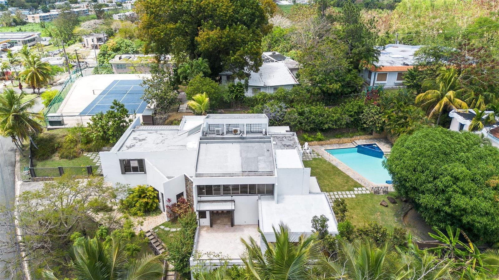 Privacy, space, location and exclusivity are just some of the perks that have this one of a kind property, located in Baldwin Guaynabo. It boasts 1,532 SQM lot with 4,690 SQFT of gross living area all in marble floors, an indoor patio and a professional tennis court in an additional 913 SQM lot. With 5 bedrooms up to 7, this house has the space to accomodate every need: an office, gym, in-laws, game room, and more.
Enjoy the spacious backyard with a full terrace, outdoor kitchen, pool table, and a relaxing pool in the peacefulness of your own home.
The garage is attached to the house for 2 cars, but has the capacity to convert it in 3 cars garage. Beside, has the space for 4 additional vehicles without any obstruction.
Have your organic fruits from your own backyard like: avocados, tamarinds, mangoes, lime, and more.
In case of emergency you are already ready with with electric window shutters, 2 power generators, water cistern and a solar water heater.
Make this unique house your home.