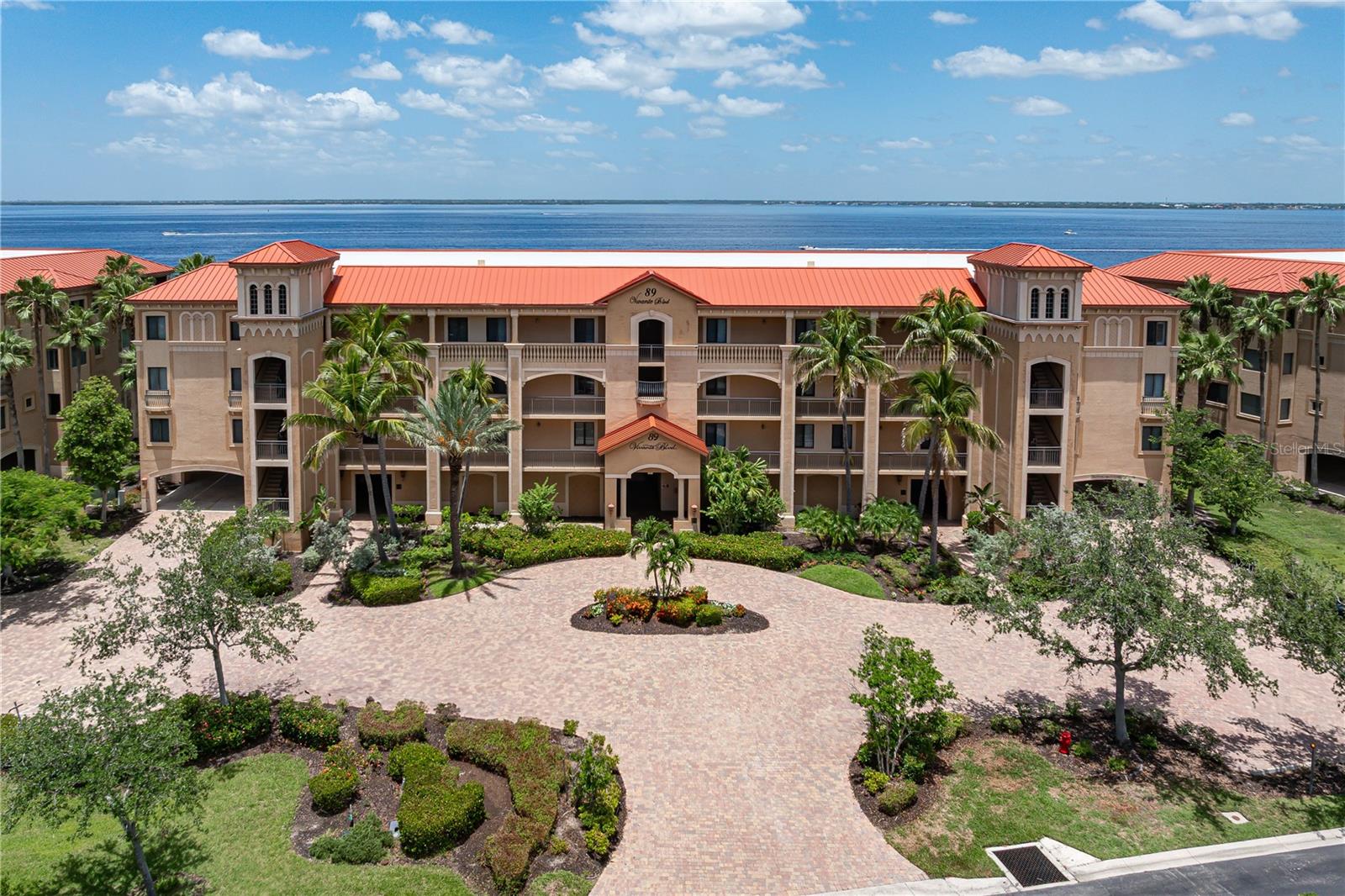 TOP-FLOOR WATERFRONT LUXURY W/PRIVATE ELEVATOR & BREATHTAKING HARBOR VIEWS - Enjoy front-row seats to sweeping views of Charlotte Harbor from this top-floor, 3 bed/3 bath condo in the resort-like community of Vivante in Punta Gorda Isles. Boasting over 2,300 sqft of living space, this spacious condo offers a private elevator that opens directly into a large foyer. The foyer can be used as a welcoming entryway or even redefined to be used as a charming reading nook. Either way, it sets the tone for the elegance within. High ceilings and a blend of tile and new wood-look luxury vinyl plank floors enhance the open, airy layout. The great room design offers a seamless flow between the living and dining spaces, with sliding glass doors drawing your eye toward the water beyond. From morning coffee to evening cocktails, the screened balcony is your front-row seat to unmatched, full-harbor views, where sunsets light up the sky and boats glide across the horizon. The chef’s kitchen features granite countertops, dark stainless steel appliances, wood cabinetry, a breakfast bar, a center island with storage and power, and a closet pantry. Wake up to captivating harbor views in the owner’s suite, which offers walk-out balcony access, dual walk-in closets, and a luxurious bath with split vanities, a garden tub, a glass-enclosed shower, and private water closet. The split-bedroom floor plan provides exceptional privacy with two large guest bedrooms—each with a walk-in closet. One guest room includes a private en-suite bath, ideal for long-term guests. While a pocket door separates the other guest room and guest bathroom from the rest of the unit. Additional highlights include a dedicated laundry room with full-sized HE washer & dryer, utility sink, and extra storage, as well as a generous row of hallway closets. There is also a deeded under-building parking space and private garage storage unit. Vivante is a gated, waterfront community offering world-class amenities: a 12,000 sq ft clubhouse with fitness center, sauna, and billiards; two heated, in-ground pools (lap & resort-style); heated spa; six Har-Tru tennis courts; on-site spa and seasonal tennis pro; group classes; and an active social calendar—all set against the backdrop of lush, Mediterranean-inspired, tropical landscaping. This is your chance to enjoy a vibrant Punta Gorda lifestyle—known for its boating, fishing, golf, bike trails, and thriving arts & dining scene. Schedule your private showing today and claim your place in paradise.