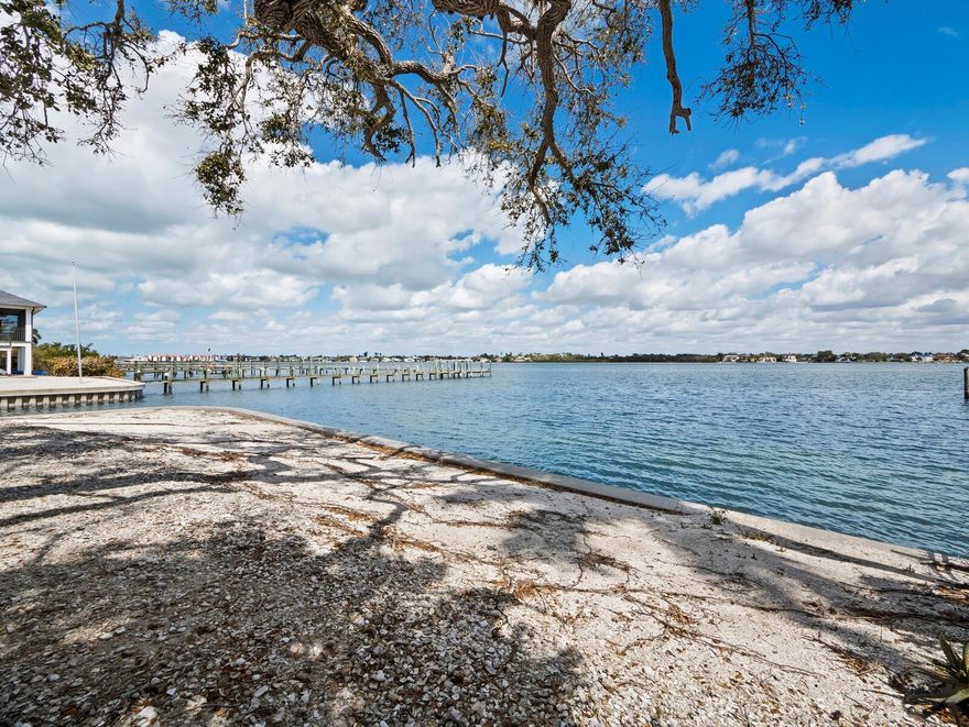 A rare opportunity on Siesta Key’s Little Sarasota Bay. Positioned at the end of a quiet street in the established Midnight Harbor neighborhood, this 0.45-acre bayfront lot offers 287 feet of water frontage, approximately 92 feet along the bay and 195 feet along a protected saltwater canal, creating water on two sides and expansive open water views. The property is being offered for land value and presents an exceptional canvas for a new custom bayfront estate. The existing structure is not being marketed for renovation, allowing a buyer or builder to focus fully on designing a residence that maximizes the site’s orientation, water views and waterfront lifestyle potential. The bayside seawall was replaced in 2014, along with 20 feet of canal seawall. The protected canal frontage provides practical boating access with sailboat water and no fixed bridges, allowing direct navigation to the Intracoastal Waterway and Gulf beyond. The depth of the lot and the dual water exposure create compelling opportunities for architectural design, outdoor living spaces and waterfront amenities. The site is enhanced by mature coastal trees that contribute character and scale, elements often absent in newly created waterfront parcels. With nearly half an acre and substantial waterfront exposure, the property offers the scale required for a significant new coastal residence designed to modern building standards and elevated construction. Just minutes from Siesta Beach and offering convenient access to the mainland via the Stickney Point Bridge, the setting combines island privacy with proximity to Sarasota’s dining, cultural and entertainment districts. Waterfront redevelopment opportunities with this amount of bay and canal frontage on Siesta Key are increasingly limited, making this property a compelling investment for a builder, developer or buyer seeking to create a legacy waterfront home.