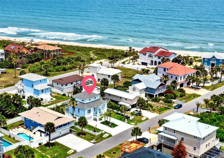 Ocean view beachside home in desirable Marineland Acres.  Short Term Rental Potential.   Sparkling clean and ready for full time living, vacation home use or STR as no rental restrictions.  Miles of soft sand await just a minute walk away (350').  Spend your day shelling, surfing the waves, walking your dogs, or just relaxing on the beach.  No rocks.  No crowds, No condos.  Just a tranquil neighborhood beach.  Come home and rinse off in the outdoor shower and revel in the beautifully landscaped yard with raised planter box.  Room for children or pets to play in the fenced back yard. This home is ideally located steps from the beach yet set back enough to have great landscaping.  Well designed with over 4,050 total sqft. Generator and manual transfer switch.  Extra room to park multiple cars, a boat, or RV on Shark coated drive.   From top to bottom starting with the 400 sq/ft Sky-deck with its sweeping ocean views and orange sunsets, this home stands out.  Primary bedroom suite is on the 3rd floor (588 sqft) with California walk in closet, en-suite bath featuring a large shower and dual sinks.  The main level has over 1,300 sq/ft of living space. Floors are easy care Travertine tile.  A spacious kitchen with granite countertops, stainless appliances, gas range, and eat at bar.  Great room features a gas fireplace and dining area, along with full bath and 2 large guest bedrooms complete this level.  Large covered deck wraps around the home w/ cool ocean breezes and the sounds of breaking waves.  Ground level of 1,764 sq/ft has 2 oversized garages and central storage area for all your beach toys. There is a dumb waiter for easy transfers to upper level. Room for golf carts or surf boards in the added work shop area. Lots of storage.  All concrete block first level and sturdy hardi-board type siding above. Recent upgrades include: enclosed garages w/ storage, shark coated drive, gutters, custom made impact garage doors, and much more. This spotless, well maintained home is sited on quiet paved residential street almost 1/2 mile east of A1A.  Nearby is Washington Oaks State Gardens, with its unique rock formations on the beach and formal gardens, a constant draw for weddings, photos and sunset views.  Keep your boat at home and launch from Bings Landing just 1 mile south.  Play golf at any of the 6 area courses. Use the bike paths or take a short drive to dining and/ or Publix for shopping.  Located just 25 minutes to historic St. Augustine and 30 minutes to exciting Daytona Beach you have easy access to entertainment.