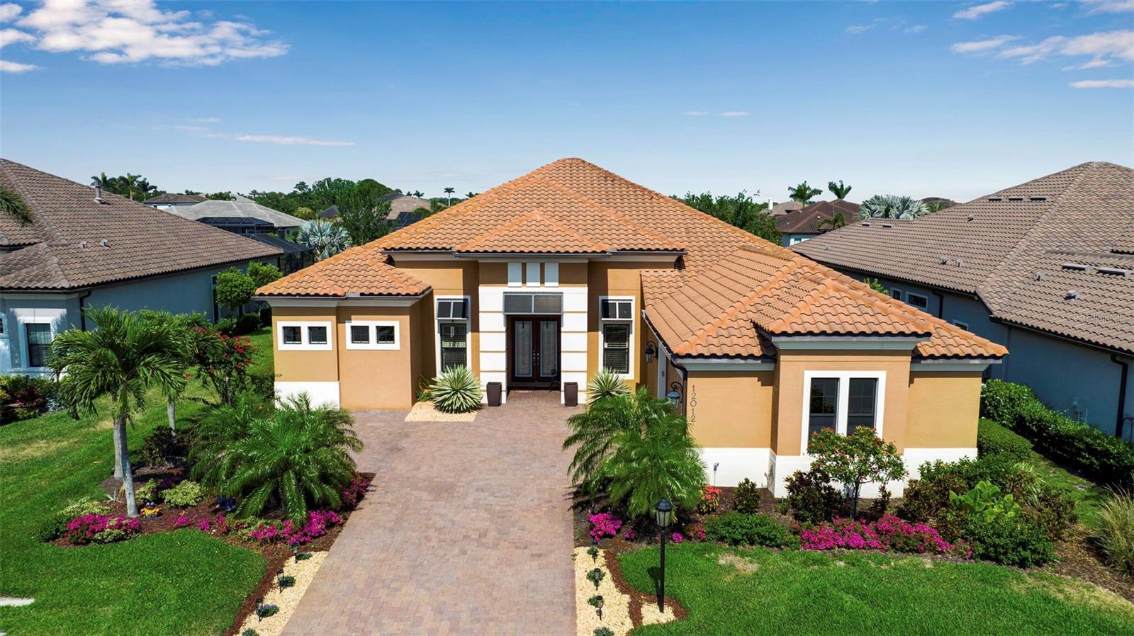 This beautiful single-story home features 3 bedrooms, 3.5 baths, an office, and a bonus room, and pool overlooking the lake, and offering luxurious living at its finest. The bright, open floor plan is enhanced by soaring ceilings, creating an easy flow from room to room. The sellers have thoughtfully upgraded this exceptional space with trayed ceilings, crown molding, plantation shutters, custom drapery, and upgraded ceiling fans. A stunning stone wall with an electric fireplace and warm color palette creates an inviting atmosphere. Outside, experience the best of Florida living with serene lake views and panoramic screens for uninterrupted enjoyment of the natural surroundings. Multiple areas invite relaxation and entertainment, including a lanai with an outdoor kitchen, paver brick decking, and pool. Enjoy a maintenance-free lifestyle with groundskeeping provided by the association. For those seeking to complement their lifestyle, the clubhouse offers a fitness center, yoga and massage rooms, locker rooms, and a game room, as well as tennis, pickleball, and bocce ball courts, and even two dog parks. Legacy Estates is a gated community with resort-style amenities, including the Bahama Bar Restaurant next to a beach-entry pool, heated spa, and a kid-friendly splash and play area. The location provides easy access to the Legacy Trail and nature trails for walking and bicycling for the outdoor enthusiast. Conveniently located near A-rated schools, shopping and dining options abound, and a short drive will take you to some of the most beautiful beaches in the world!