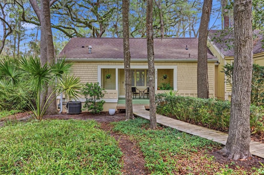 One or more photos were virtually staged (fire shown in fireplace). Set back at the edge of a cul-de-sac in Haile Plantation, this 2-bed, 2-bath home on a wooded lot stands out for its meticulous exterior and interior updates! A 2024 roof, a freshly painted exterior, updated plumbing, and beautifully remodeled bathrooms are just some of the upgrades that make this residence truly spectacular! A wooden boardwalk leads you through lush native greenery and mature trees to a welcoming front porch that sets a peaceful tone. Once through the front door, you enter a light-filled living room with a vaulted ceiling, luxury vinyl plank flooring, and a fireplace with a painted brick hearth that serves as the central focal point of the home. This space flows effortlessly into the dining area and a well-appointed kitchen featuring granite countertops, dark cabinetry, a classic subway tile backsplash, and stainless steel appliances. Adjacent to the kitchen is an oversized laundry room that offers extensive pantry shelving for maximum storage. All-new interior doors open to reveal inviting bedrooms, each featuring a charming built-in window seat, the ideal nook for reading and viewing the lovely surroundings. The remodeled bathrooms include a private primary ensuite updated in 2025 and a guest bathroom refreshed in 2026, both finished with designer tile work and modern vanities. With access to the newly finished back deck from both the living room and the guest bedroom, this home is ideal for relaxing outdoors while overlooking a backyard that borders tree-lined common areas. This residence offers a lifestyle of ease within the winding trails of the community, placing you just a short stroll from the vibrant Saturday morning Farmer’s Market and the boutiques of the Village Center. Beyond the neighborhood, you are conveniently positioned for a quick commute to UF, Shands, and North Florida Regional Medical Center, with Gainesville’s premier dining and shopping just minutes away. Reach out today to claim this polished gem as your own and start your next chapter in one of Gainesville’s most cherished neighborhoods!