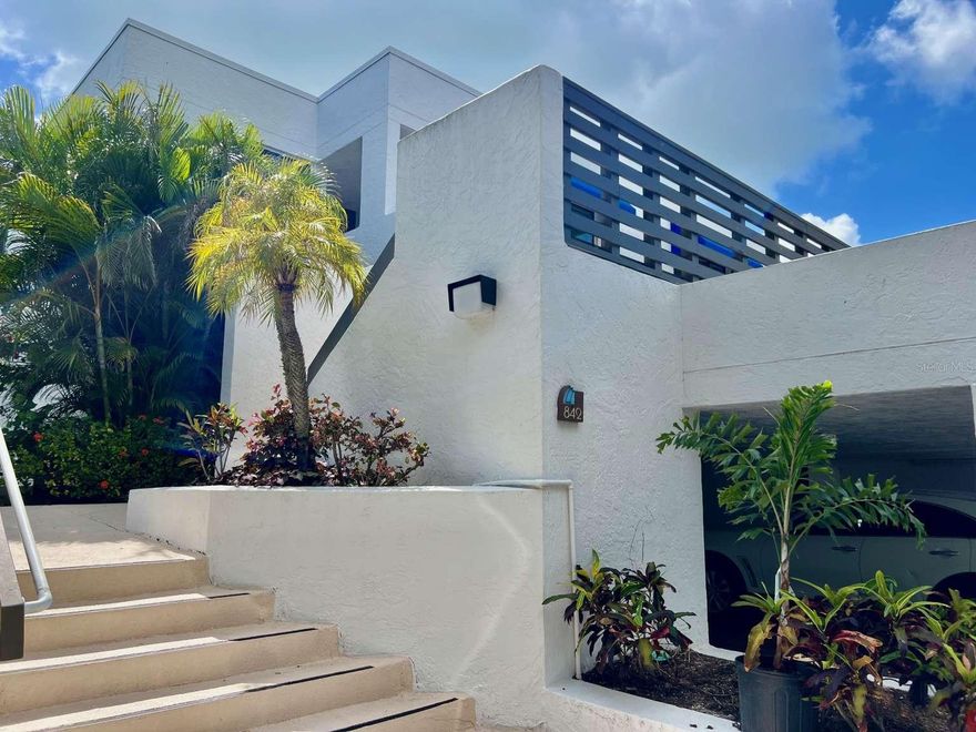 This exceptionally clean and well maintained 2-bedroom, 2-bath residence in Bayport Beach and Tennis Club is offered turnkey, ready for immediate enjoyment. Currently the lowest-priced unit in the community, it also presents a rare opportunity for a new owner to customize and renovate at their own pace—adding personal style while building value. Ideally positioned as a bright and private second-floor end unit with no neighbors above, this home is filled with natural light. Kitchen, dining, living room open design with split bedrooms for privacy. The primary suite features a walk-in closet and a dedicated office niche—perfect for today’s work-from-home lifestyle. Two inviting outdoor living spaces—a private open-air deck and a screened lanai overlooking the tropical gardens—create the perfect setting to relax and unwind. Additional highlights include covered parking, ample guest parking, two private storage areas plus an owner’s closet, and the convenience of an in-unit full-size washer and dryer. Set on 27 acres of beautifully landscaped grounds on Longboat Key, Bayport is a sought-after gulf-to-bay community designed by renowned architect Tim Seibert. Residents enjoy 1,200 feet of deeded private beach access along the Gulf of Mexico. Community amenities are exceptional, including a Junior Olympic-size heated pool—one of the largest on the Key—four Har-Tru tennis courts, a fitness center, fishing pier, and kayak launch. Beach chairs and umbrellas are provided, and a full calendar of seasonal social activities fosters a vibrant yet relaxed coastal lifestyle. Meandering shell pathways and meticulously maintained tropical landscaping complete the serene setting. Experience the best of island living with breathtaking sunrises over the bay, unforgettable sunsets on the beach, and everything in between.