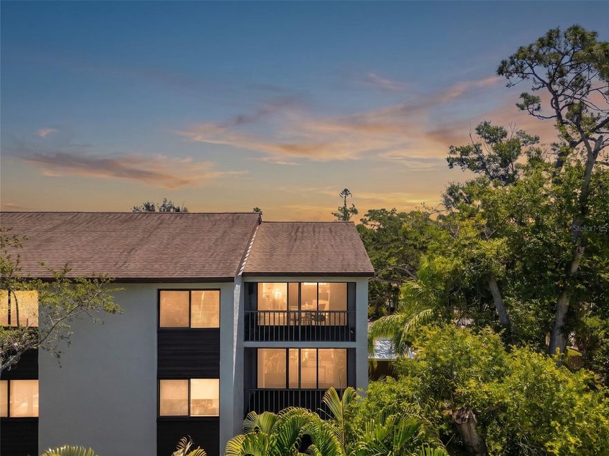 Top-floor corner unit at Orchid Oaks that comes fully furnished, turnkey, and move-in ready. This beautifully updated 2BD/2BA, 1,376 sq ft condominium is tucked beneath a canopy of mature oaks just off Phillippi Creek, offering the rare combination of natural serenity and central Sarasota convenience. The updated kitchen has been opened up and features a hood, wine fridge, and ample cabinetry. Open living and dining areas flow seamlessly to a screened lanai with electric fireplace and TV overlooking the community pool with a true treetop escape. Primary suite has a king bed, walk-in closet, and en suite bath. Guest bedroom with two twins. No carpet, only tile and LVP throughout the unit.  The in-unit laundry is right off the entry with cabinetry. One covered assigned parking space. Community has additional parking available and amenities include a pool, clubhouse, gazebo, walking trails, a dog run, plus a creekside dock. The association maintains and provides private access to the shopping center next door and the HOA dues include elevator, water, sewer, cable, pest control, roof, painting, lawn service, exterior maintenance and building insurance. 30-day minimum lease allowed up to three times per year which makes it an excellent for option for seasonal use or income production. Minutes to Siesta Key, Downtown Sarasota, SRQ Airport, golf, dining, and shopping. Relaxed Florida living at its finest.