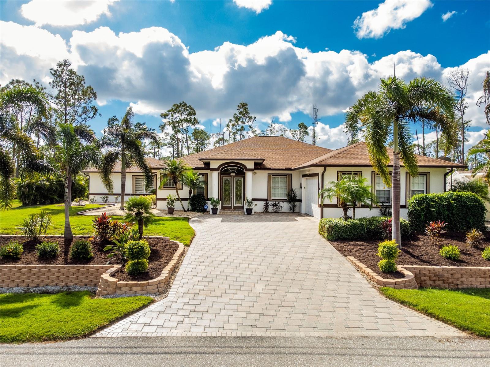 4 beds, 2 1/2 baths + den over 3,000 SQFT home on double lot. Drive up and you see the exquisite landscaping done on both lots with paver driveways and walkways around the home and detached garage. Walk in and view the massive great room open with 8-foot sliders to the private paradise in the back yard and pool area. The kitchen is open, warm with wood cabinets and granite countertops. A luxurious master suite, private office/study, a 10x25 family/Florida room - then there is still more! The 22x29 foot recreation room/guest room with closet and half bath has endless possibilities! All of this luxury open to the incredible pool area with paver brick deck and view of mature areca palms. Over 700 SQFT 2 car detached garage/workshop with recently epoxied floors. Do not miss the opportunity to own this secluded masterpiece.