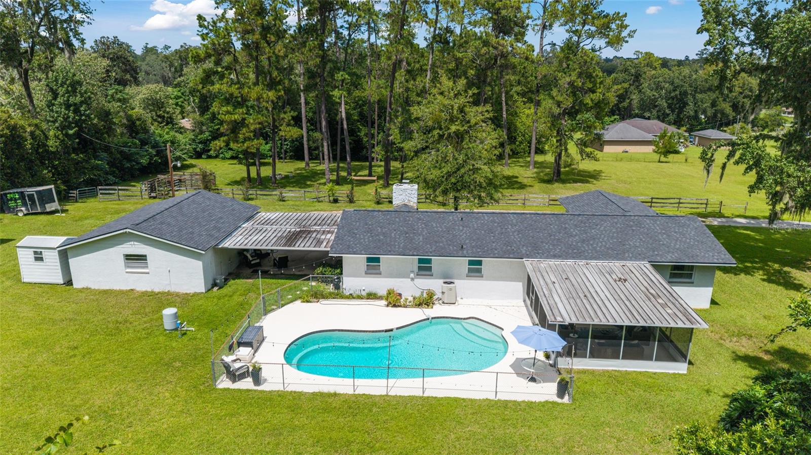 Property on almost 4 acres in SW Ocala offers the perfect blend of comfort, space, and country charm. This ranch-style home features 4 bedrooms, 2 bathrooms, and over 2,000 sq ft of living space. Inside, the open layout highlights a beautiful stone fireplace, kitchen with granite countertops, and a bright split-bedroom design. Step outside to enjoy a screened patio, private in-ground pool, and wide-open pastures with a two-stall barn, detached garage, and storage shed. With no HOA or deed restrictions and just minutes from shopping, dining, and I-75, this property delivers both privacy and convenience.