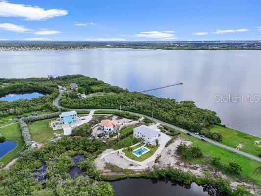 An exquisite, newly constructed stilted waterfront estate awaits in the community of Terra Ceia. Set on over 1.5 acres of lush, tranquil property with sweeping views of Terra Ceia Bay, this custom-designed residence offers the ultimate in coastal luxury and durability. Built to withstand Florida’s most challenging weather, the home is equipped with hurricane-impact windows and doors throughout, ensuring both safety and serenity year-round. Exclusive water access adds exceptional value, with a professional dock and seawall estimate from Duncan Seawall & Docks included in the disclosures. A mosquito misting system around the perimeter ensures peaceful outdoor living, while the elevated construction blends elegance with intelligent engineering.
Inside, every detail is curated for refined living. The primary suite is a luxurious sanctuary, featuring custom his-and-her walk-in closets, an MTI heated shell soaking tub with microbubble therapy and a mirrored TV, a steam shower with rainfall and handheld options, dual vanities with anti-fog mirrors, a quartz bench, and a private water closet. An angled tray ceiling adds architectural dimension, and a private slider opens directly to the front porch for seamless indoor-outdoor enjoyment.
The gourmet kitchen is a true showpiece, appointed with high-end Café appliances, a six-burner gas range, pot filler, and soft-close cabinetry. Cambria quartz countertops and a dramatic center island with brass accents elevate both function and style. A hidden butler’s pantry, wine and beverage fridges, soft nugget ice maker, and champagne brass sink complete the space for effortless entertaining. The main living area is anchored by a modern Dimplex Opti-V electric fireplace, while integrated USB outlets provide contemporary convenience.
Thoughtful layout and flow continue throughout the home with a Jack-and-Jill suite connecting two spacious bedrooms, and a private fourth bedroom off the laundry room featuring its own en-suite bath and walk-in closet. Additional highlights include a Rinnai tankless water heater, a hydraulic elevator, a 22,000-watt generator with an oversized gas tank, and a unique three-staircase design connecting the front porch, side entry, and back lanai.
The oversized 40' x 20' brushed-concrete pool provides the ideal setting for both recreation and relaxation. The outdoor kitchen is fully equipped with gas lines for a two-burner grill, sink, and a Renaissance cooking system set on natural quartz surfaces—perfect for al fresco dining.
Optional membership in the Terra Ceia community offers access to Sea Breeze Park, a newly constructed playground, a fishing pier, and a community dock. Social gatherings abound with seasonal events, regattas, food trucks, and a brand-new pickleball court, creating a vibrant, welcoming atmosphere.
With its impeccable design, premium finishes, and unmatched resilience, this waterfront retreat offers a rare opportunity to live luxuriously in a peaceful yet active coastal enclave. Schedule your private showing today.