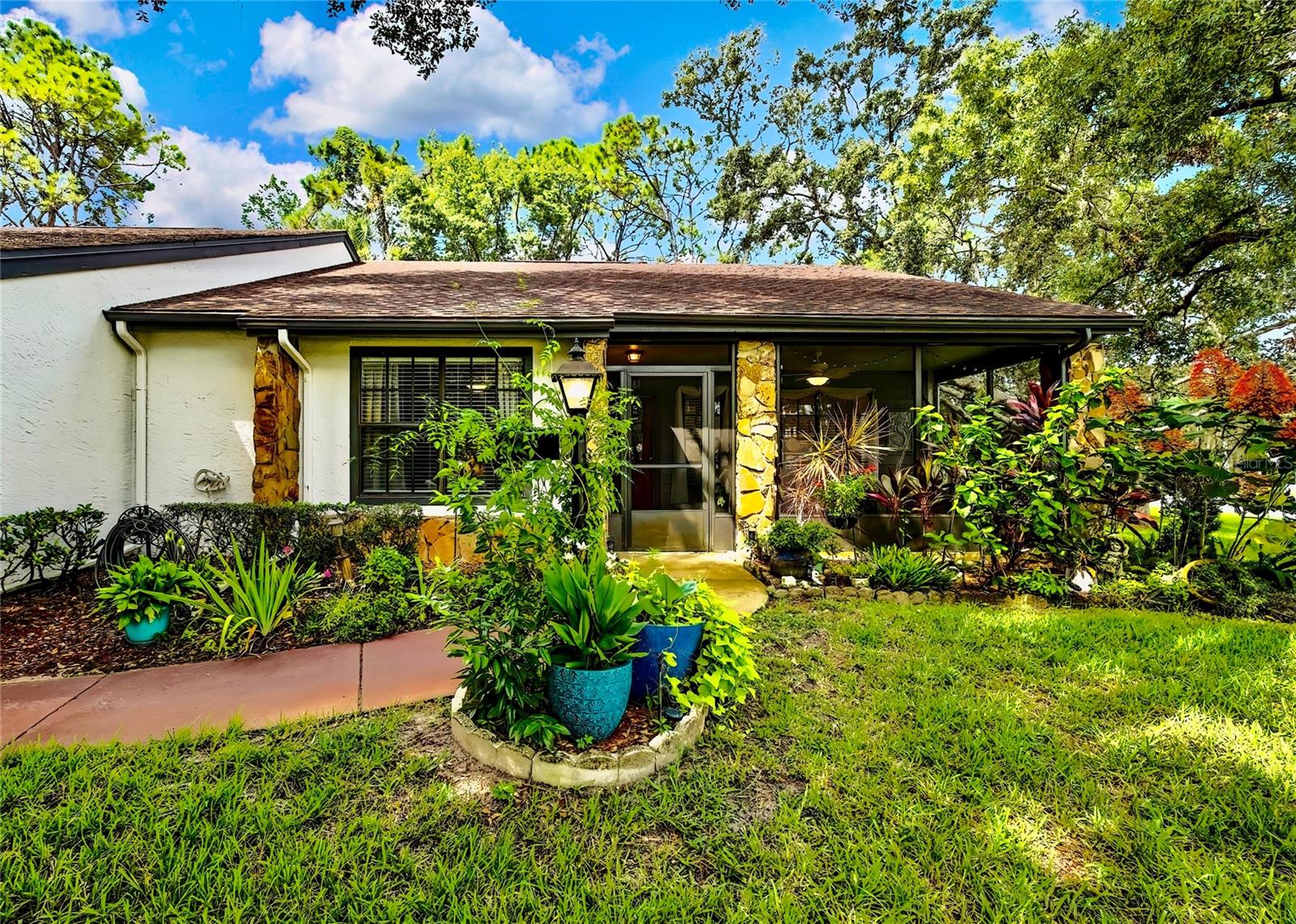 Welcome to maintenance-free living in Timber Pines, Spring Hill’s premier 55+ gated golf community. This beautifully updated 2-bedroom, 2-bath end-unit villa offers comfort, convenience, and an active Florida lifestyle. With 1,197 square feet of air-conditioned living space and 1,768 total square feet under roof, there’s plenty of room to relax, entertain, and enjoy life. Step inside to find luxury vinyl plank flooring, a freshly painted interior, updated lighting, and a modern kitchen with updated cabinets and appliances, creating a bright and welcoming space from the moment you enter. Both bedrooms are generously sized and feature walk-in closets for ample storage. At the rear of the home, an enclosed Florida room offers additional living space and is currently being used as a home office. Enjoy your morning coffee on the spacious screened front porch or take in the peaceful surroundings from this desirable end-unit location. The covered carport includes a secure storage closet for added convenience. This home also features motorized hurricane window coverings for added protection and peace of mind. Located just a short stroll from The Lodge and the Resident Activity Center, you'll have easy access to all the exceptional amenities Timber Pines has to offer including four golf courses, two clubhouses, a performing arts center, twelve lighted pickleball and tennis courts, two heated and cooled pools with spas, a fitness center, billiards room, woodworking shop, arts and crafts studio, shuffleboard, horseshoe pits, and bocce ball. The HOA fee includes lawn maintenance, basic cable, and internet, providing you with low-maintenance living and more time to enjoy the activities you love. Conveniently located near shopping, dining, medical facilities, and just minutes to U.S. 19 and the Suncoast Parkway for easy access to Tampa International Airport, award-winning beaches, and world-class entertainment. Homes like this don’t last long in Timber Pines so schedule your private showing today and experience the lifestyle you've been waiting for.