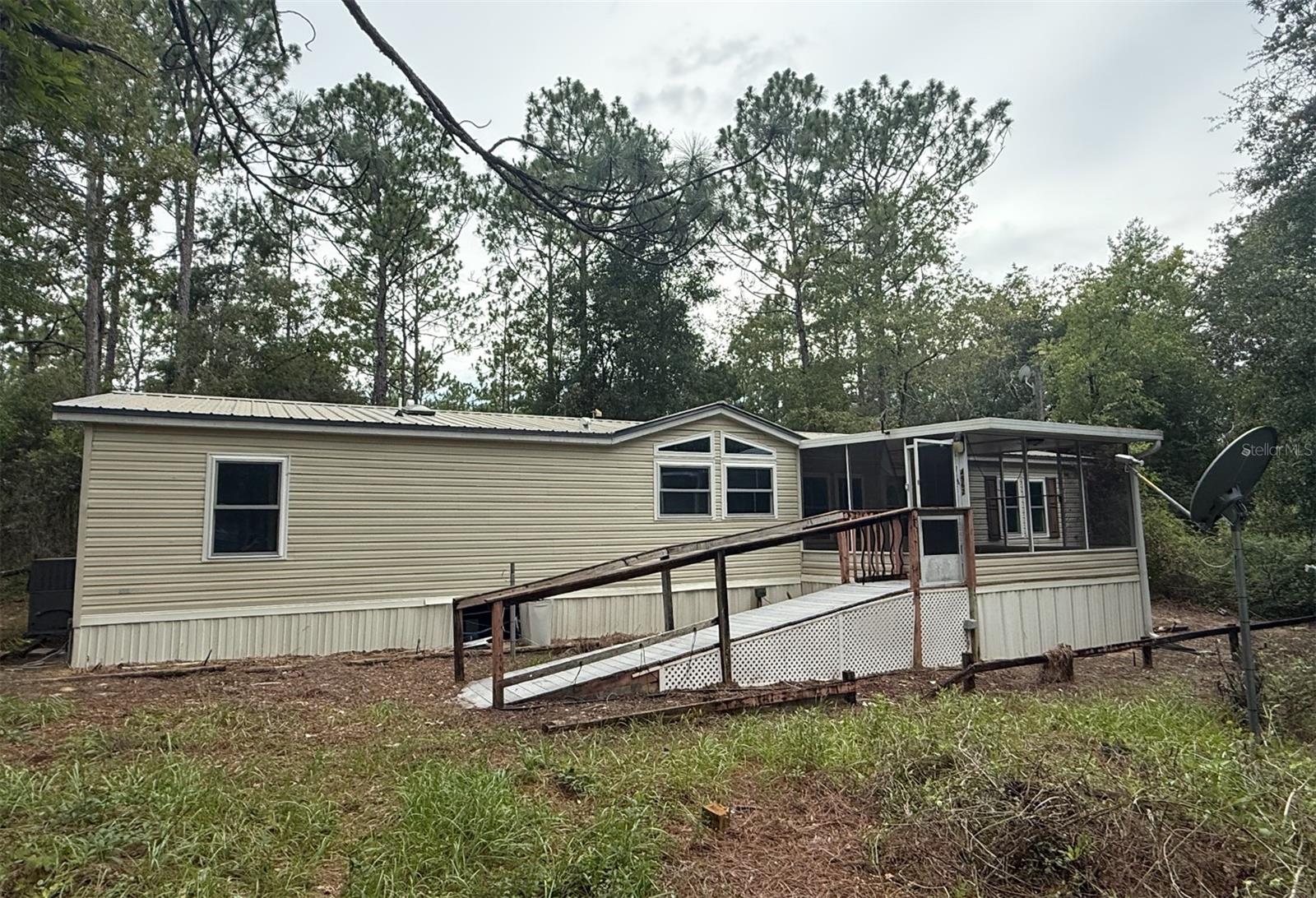 This property is such a deal, I would buy it if I could!  With vacant land now selling at $60,000 to $100,000 an acre in Ocala, the location of this secluded 3.5-acre property at the end of a private cul-de-sac is the hottest deal in the area if you are looking for a solid Manufactured Home with your own private, gated compound with a completely fenced-in lot and natural pine tree privacy border. This 3 Bed; 2 Bath, 1,715 sf Manufactured Home built in 1997 has a NEW SOLID METAL ROOF 3 2016 and also includes a new standalone solar system with electrical run, septic, and well that is fully paid for. Located in the highly desired Classic Hills subdivision in Ocala, it is a short walk to Duffy’s and just a 5-minute drive to the world-famous World Equestrian Center and Rainbow Springs State Park. With an after-repaired-value estimated in the $300k range, the home is being listed as-is, below market, as a light fixer-upper requiring new flooring, paint, and minor repairs. It is perfect for the do-it-yourself handyman to get a below-market deal on a highly valuable home. The owner may consider partial seller financing. No credit required with flexible payment terms.