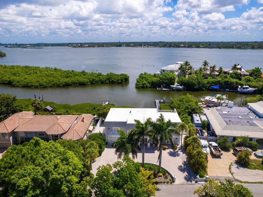 This splendid waterfront retreat on Siesta Key offers the ideal blend of luxury, comfort and coastal charm. In an enviable location known for world-renowned beaches and vibrant island living, this gracious two-story home features four bedrooms, four full baths and two half baths, creating an oasis for discerning buyers. The home showcases breathtaking views of the Intracoastal Waterway and bay from nearly every room thanks to expansive sliding glass doors that allow for seamless indoor-outdoor living. Upon entry, the grand foyer opens to a spacious great room overlooking the heated pool and marble-tiled deck. The first floor includes a large family room with a wet bar, a pool bath, and a versatile office space that could easily serve as a fourth bedroom with an en-suite bath. A convenient full bath and laundry room near the pool add practicality to the thoughtful design. The second-floor primary suite is a tranquil retreat, complete with an en-suite bath featuring a jetted soaking tub, a separate sitting room and access to a private deck. Enjoy sunrise views, coastal breezes and serene moments while overlooking the water. A split bedroom plan ensures privacy for guests, with two additional en-suite bedrooms on the second level. The upper living room, featuring a marble-surround wood-burning fireplace, and the formal dining room add elegance and comfort to the home. The eat-in kitchen opens to an upper deck, ideal for alfresco dining with picturesque water views. Outdoor living is a highlight, with a private dock on a protected lagoon with direct access to Roberts Bay, the Intracoastal Waterway and Gulf of Mexico. The fenced yard, heated pool and spacious pool deck are ideal for entertaining or simply enjoying the serene surroundings. Close to Siesta Beach and the Village, this home also offers convenient access to downtown Sarasota's fine dining, shopping, art galleries and cultural venues. This is coastal living at its finest, luxury, convenience and charm all in one exceptional property.