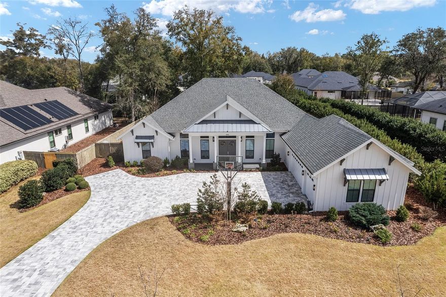 Immaculately upgraded Barry Bullard home featuring exceptional, custom-built enhancements throughout. Situated on a special 0.44-acre lot, the property offers beautiful natural conservation views and a convenient walking path along one side. This impressive single-story, 3,575 sq. ft. residence includes 4 bedrooms, 4 bathrooms, plus a dedicated office and separate media room.  Extensive upgrades include French oak hardwood (engineered) flooring throughout, custom floor-to-ceiling kitchen cabinetry, and a premium Wolf/Sub-Zero/Cove appliance package. The gourmet kitchen is the heart of the home, anchored by an oversized island with high-end quartz countertops and abundant storage. It opens seamlessly to the family room with its gas-burning fireplace and the dining area, creating an ideal space for both everyday living and entertaining. Oversized windows and fully retractable glass sliders fill the home with natural light and showcase beautiful views of the pool, spa, and lanai.  The open, split floor plan offers both comfort and privacy. The spacious primary suite is located on one side of the home and features private lanai access, two walk-in closets, a garden tub, dual vanities, and a walk-in shower. On the opposite side are two bedroom en-suites, while the rear of the home features the fourth bedroom and the media room. The large media room, with a wet bar, could easily function as a fifth bedroom with the simple conversion of the existing book shelving into a closet.  Outdoor living is equally impressive with extended paver areas in the front and backyard, landscape lighting, custom fire pit area and summer kitchen.  The home is Control4 ready for smart home integration and includes surround sound speakers as well as remote controlled motorized window shades.  Privacy is a standout feature, with a fully fenced backyard. In addition to the screened-in heated saltwater pool and spa, there is generous additional yard space for relaxing or entertaining. A quiet promenade directly to the south provides added greenery and distance from neighboring homes.  For peace of mind, the home is also equipped with a whole-house generator for power outages.  Located in the highly desirable Estates of Wilds Plantation, where every home is a custom, high-quality build and natural preservation is a priority, this property offers an exceptional lifestyle.  Experience it in person to truly appreciate everything it has to offer.