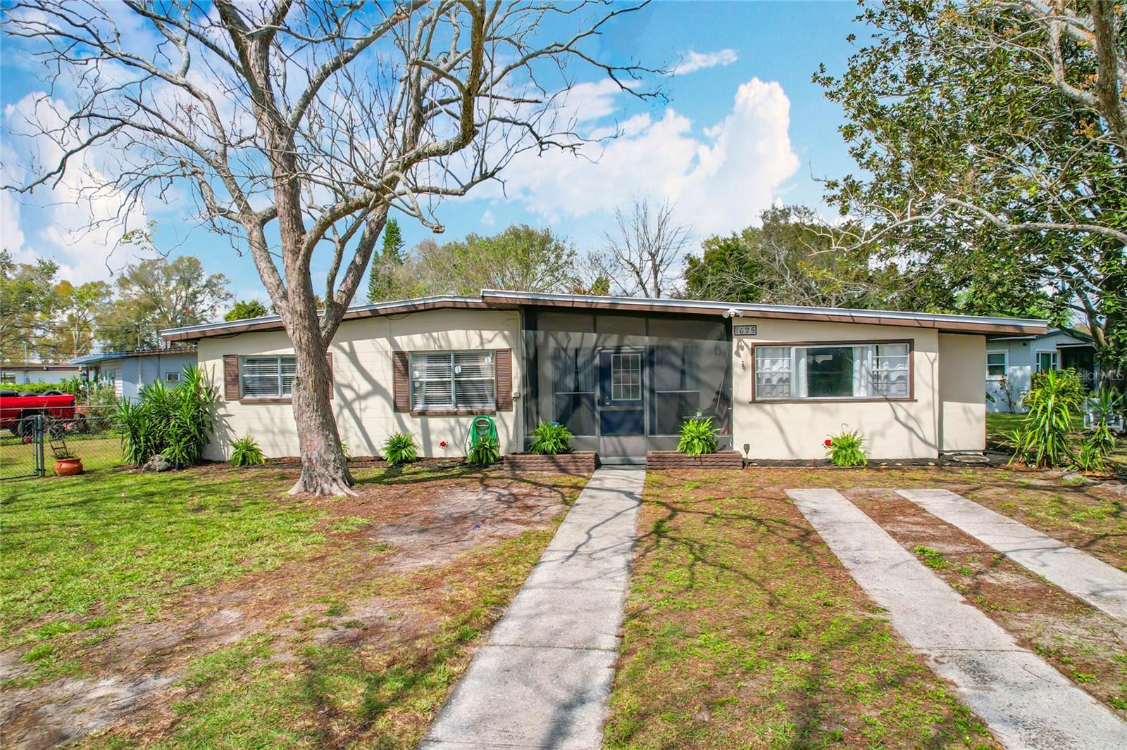Charming 3-Bedroom Home on Oversized Corner Lot – Available for Rent! or Sale!
Discover this inviting 3-bedroom, 1-bath single-family residence featuring 1,490 sq ft of thoughtfully designed living space. Perfectly located on an oversized corner lot, this home backs to open green space and offers both a screened lanai and a covered porch, ideal for enjoying your morning coffee or winding down in the evening.
Inside, the home boasts bright, spacious bedrooms with generous windows that fill the rooms with natural light. The open dining area flows into an extended air-conditioned bonus space, offering extra room for a home office, play area, or den with direct access to the outdoor patio for seamless indoor-outdoor living.
