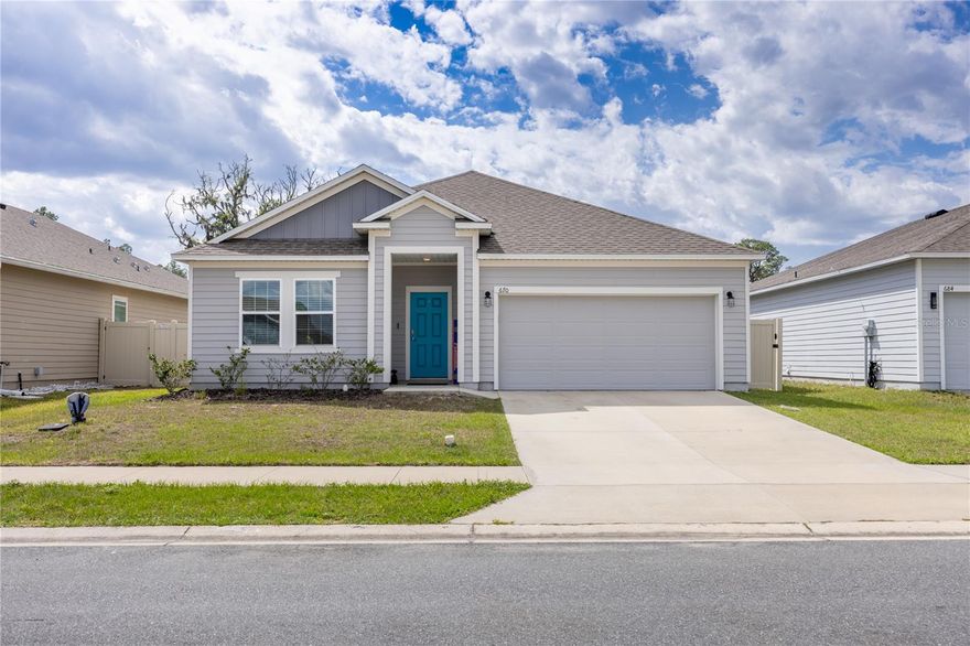 Welcome home to this beautifully maintained, like new Maronda home built in 2021, perfectly situated in the desirable Oak Park community. Thoughtfully designed with both comfort and style in mind, this 3 bedroom, 2 bathroom plus bonus room home offers a bright and open layout that feels inviting from the moment you walk through the door. At the front of the home, you are greeted by a versatile space filled with natural light from the front windows, ideal for a sitting area, formal dining room, or additional living space to fit your needs. The heart of the home features a spacious kitchen complete with a large island, dry bar, and plenty of room to gather, all flowing seamlessly into the main living area, making it perfect for entertaining family and friends. Luxury vinyl plank flooring runs throughout the home, complemented by a clean, neutral paint palette that creates a cohesive and modern feel in every room. The primary suite is a true retreat with a generous walk in closet and an en suite bathroom featuring a double sink vanity, walk in shower, and a relaxing soaking tub. The split bedroom floor plan provides privacy, with two additional bedrooms and a shared guest bathroom. An added bonus is the flexible connecting space between the bedrooms, ideal for a secondary living area, playroom, or home office. Step outside through sliding glass doors to enjoy the covered back porch overlooking a large, privacy fenced backyard, perfect for outdoor living, pets, or simply unwinding at the end of the day. This move in ready home combines modern finishes, functional space, and a fantastic location to create the perfect place to call home.