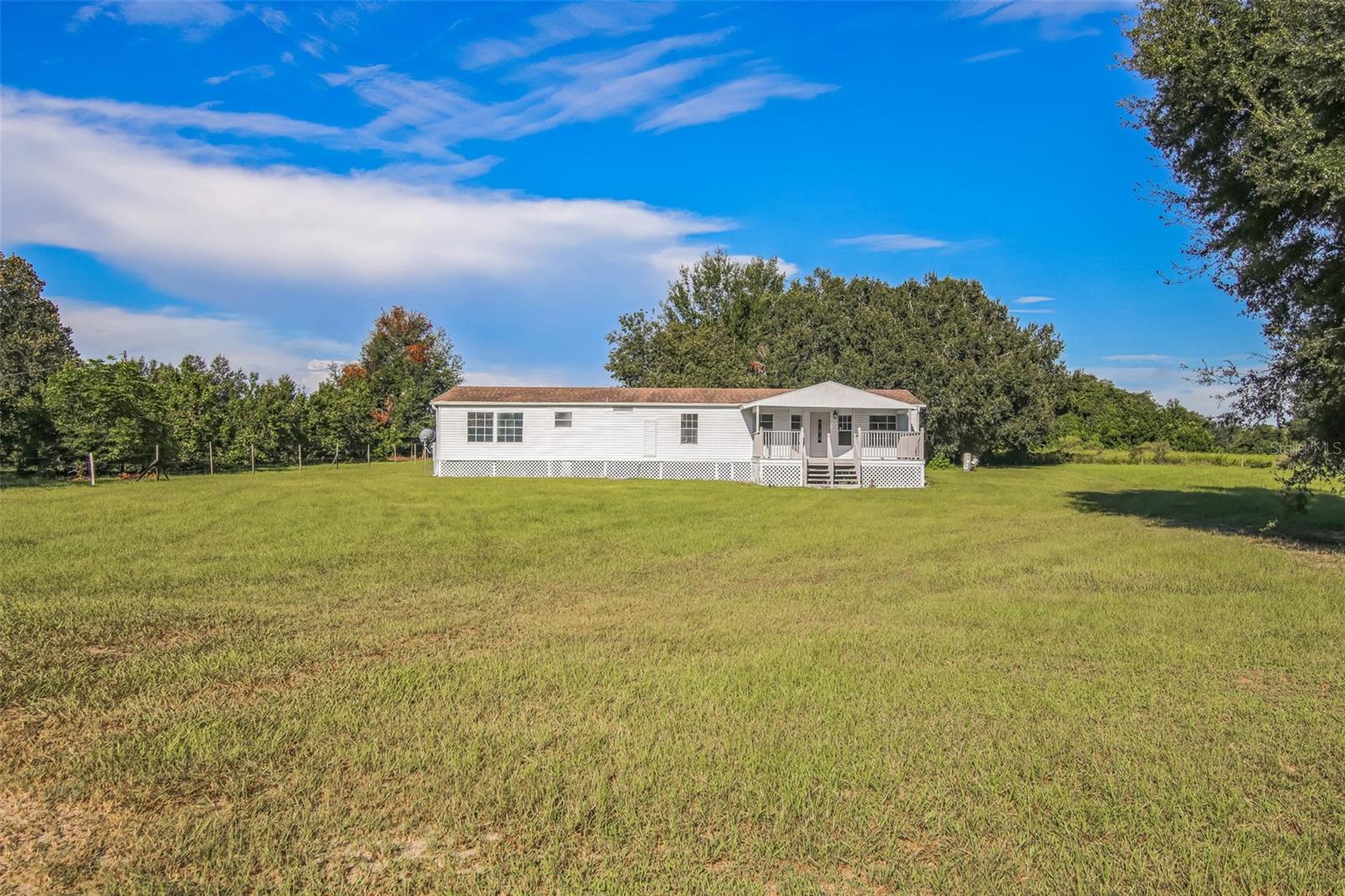 Come see this 3 bedroom/2.5 bathroom manufactured home situated on a spacious and cleared 1 acre lot in Bushnell FL! Walk up the steps of the large, open front porch-perfect for lounging and breathing in that fresh Florida country air! Inside you'll find a whopping 1900+ sqft of updated living space with vinyl flooring throughout. Large master bedroom has a full en suite with a roomy closet and combo tub/shower. Additional spacious bedroom has a half-bath attached and there's another full bath with combo tub/shower in the hall. The vaulted ceilings and plenty of large windows let in lots of natural light, brightening the home and giving it that welcoming feel. Outside, bring all your pets and toys! Enjoy a full acre of luscious green land- ready for your personal homestead or as a simple piece of peace and quiet! Stay cool with a BRAND NEW HVAC! Schedule a showing now!