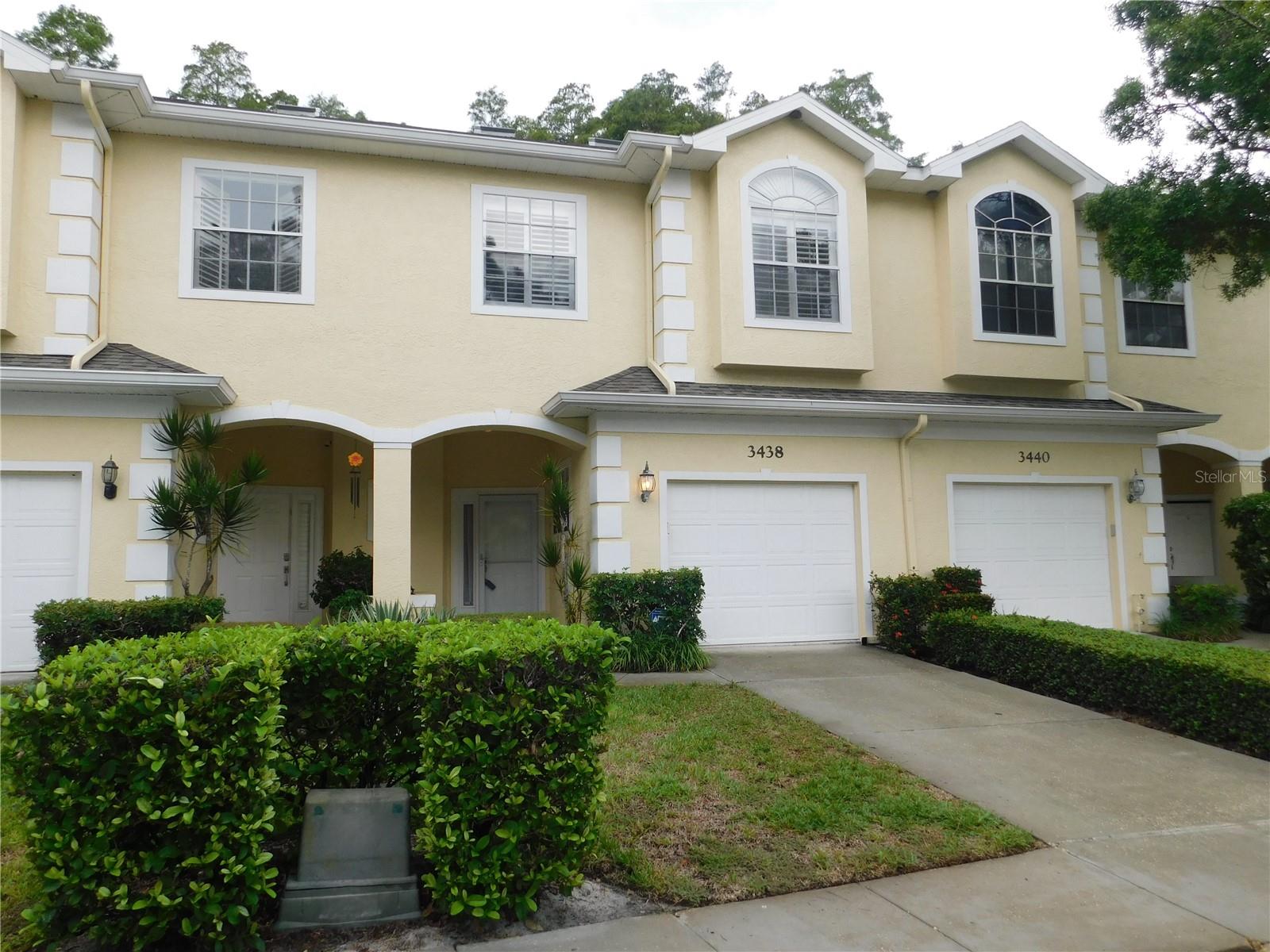 Rare townhome gem and your opportunity to own this three bedroom plus loft, 2 car garage townhome in gated Ashley Downs - an ideal location of Palm Harbor. Contemporary look, offers an open concept with high ceilings and awesome views of the conservation site wooded backdrop from your first floor tiled screen enclosed lanai AND your second floor screen enclosed wood deck off the primary bedroom. Tiled entrance foyer takes you to open area that includes spacious hall closet, half bath, entrance to private two car garage, closet pantry into open kitchen surrounded by spacious counter space, cabinets and breakfast bar into formal dining area that blends with your living area and sliding doors out to your lanai. Plantation shutters thru out! The second story has your three carpeted bedrooms. a guest bath and laundry closet with full size washer and dryer. Your primary suite feels luxuriously large with its vaulted ceilings. Plantation shutters, planters shelf with hidden soft lighting and the screened balcony which overlooks the wooded conservation behind the unit. Barn sliding door into the primary bath that has a double sink vanity, separate walk in tiled shower and private commode. Spacious walk in closet. This townhome offers a private loft/office on the third floor with its own storage closet, vaulted ceiling with skylight. This community with low monthly fees, pet friendly (pets under 25 pounds please) and community pool with gazebo, additional guest parking spaces near well desired schools, Innisbrook golf course, as well as a short drive to the beaches and parks.