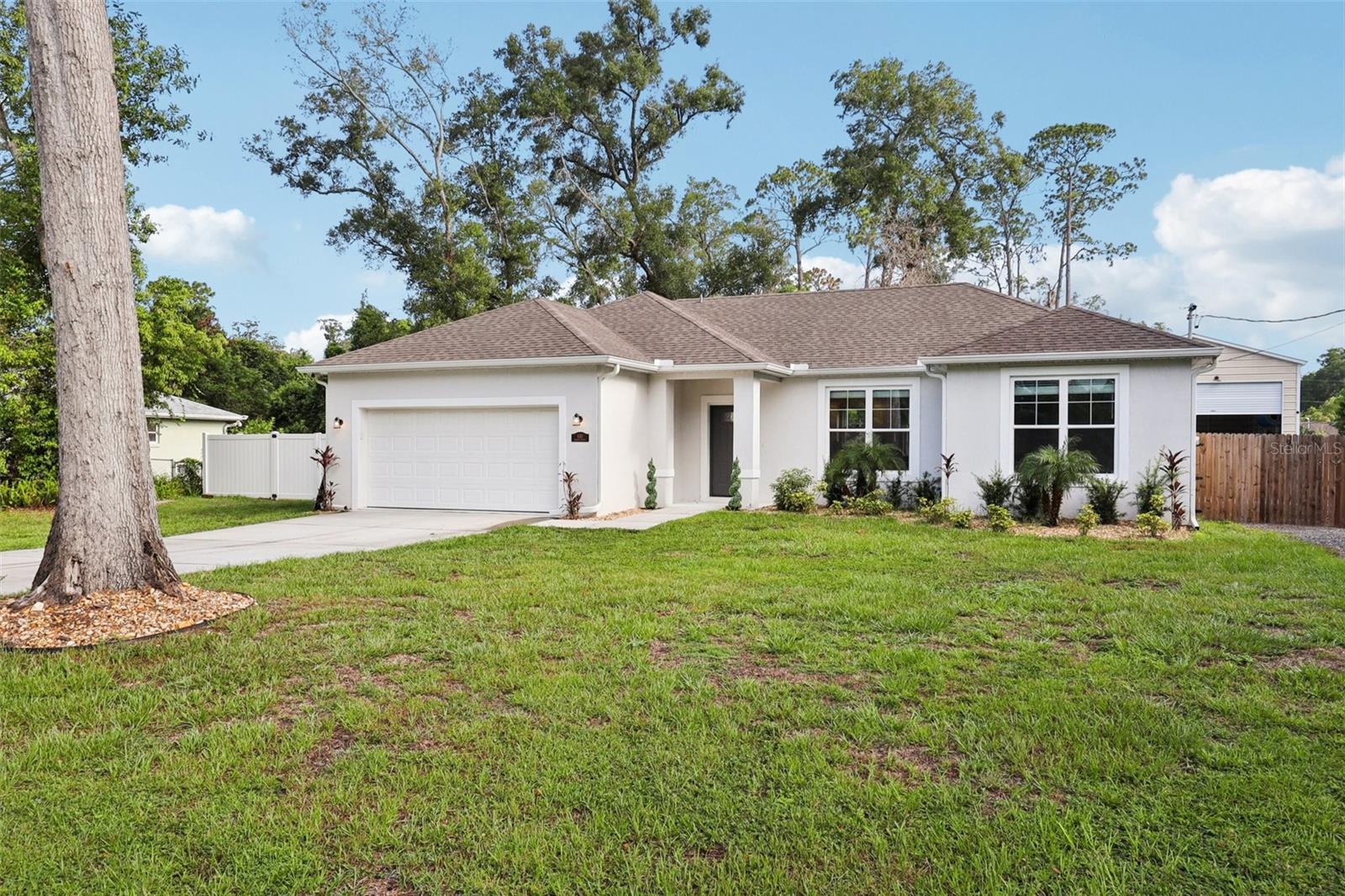 Built in 2022, this stunning 3-bedroom, 2-bathroom home combines modern luxury with smart living in a quiet, no-HOA neighborhood close to everything Central Florida has to offer. From the moment you walk in, you'll notice stylish finishes throughout, including vaulted ceilings, recessed lighting, and a Govee smart lighting system you can control right from your phone. The gourmet kitchen is a showstopper with stainless steel appliances, 42” cabinets, granite countertops, and a large island perfect for everyday living or entertaining. The spacious Owner’s Suite offers a private retreat with a huge walk-in closet and a luxurious en-suite bathroom featuring a custom-tiled step-in shower and a large soaking tub. You’ll also enjoy the flexibility of two laundry hookup options—one inside the home and another in the garage—making it easy to customize to your preference. Step outside to your personal backyard oasis—featuring a saltwater pool, hot tub, electric fireplace, and cozy fire pit. A separate driveway leads to an impressive 40x30 enclosed workshop with two garage doors (12x12 and 8x8), ideal for storing your RV, boat, or toys—or transforming into a home gym or studio. An attached lean-to outdoor kitchen and a covered patio with a built-in bar make this the perfect setup for entertaining year-round under market lights. Conveniently located near Downtown DeLand, Sanford, Orlando, and the beaches, this property offers the perfect blend of space, style, and convenience. Turnkey, smart, and loaded with extras—don’t miss your chance to call this incredible home yours!