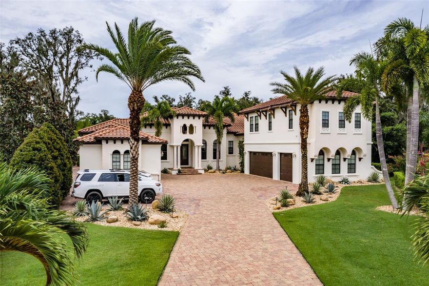 This stunning 6724 sq. ft. one-of-a-kind Fishhawk Ranch estate in gated Chapman Crossing is set on a beautifully landscaped, private 1/2 acre lot. Upon entrance you will notice the rich hardwood floors, intricate moldings, and box ceilings throughout the open concept main level. The spacious living room features a gorgeous gas fireplace and a wall of extra-large PGT mitered windows that offer an exquisite view of the stunning pool. Adjacent to the Living room you will discover the inviting and magnificently appointed gourmet kitchen. Custom wood cabinets with gorgeous granite countertops frame the large kitchen anchored by a large center island with its own prep sink. The kitchen features a 6 burner gas range with double ovens and a pot filler, a Sub-Zero refrigerator, a brand new Bosch dishwasher, a built-in microwave recess, and a large beverage refrigerator. There is an abundance of storage provided by the solid wood custom cabinets with numerous pull-outs, deep drawers, built-in cookbook niches, and a fully hidden and spacious walk-in pantry. A butler’s pantry and a built in desk area complete the magnificent kitchen area. Connecting the kitchen to the Great Room is a large conveniently placed breakfast bar. The Great Room is full of natural sunlight with wrap-around corner glass sliders that can be opened completely providing seamless transition between the Great Room and the outdoor spaces. An Epson projection system with a 116” screen makes this gathering space a family favorite. Three large bedrooms and three full baths sit off the back of the Great Room area. The large private office is complete with French doors. The Master Suite boasts large His and Hers walk-in closets, a large sitting room with windows, a door leading to the pool area and four box picture windows with electric shades. The Master Ensuite is expansive including dual vanities, soaking tub, and walkthrough shower. On the other side of the home you will find the oversized game room boasting French door access, a large storage closet, and wall to wall sliders opening completely to the outdoor space. Just off of the kitchen area you will find a built-in desk area that then leads to a full mudroom with built in benches and storage. The immense laundry room complete with granite countertops with sink, storage cabinets, and a door leading to the side yard. Off of the laundry room you will find the staircase leading you to the 2nd floor front wing boasting a full kitchen, large bonus room/living area, bedroom, and a full bath. This space is perfect for any in-law suite/teenagers/homeschool space. A staircase from the Great Room leads you to the Back Wing of the house, which includes a bedroom, bathroom, and a bonus/workout room with French door access leading to a covered balcony overlooking the grand pool and lanai covered basketball court. From this lanai enclosed balcony you will have full view of the breathtaking outdoor space featuring the custom painted resort style pool including a 15x15 shallow depth play area, 10 person hot tub, outdoor bathroom, fire pit area, covered basketball court, and artificial turf covered back and side yards. The backyard is completely private featuring a beautiful butterfly garden. This one-of-a-kind dream home is located in the highly desired Fishhawk Ranch Community that offers resort style community pools, workout facilities, basketball/tennis courts, skate park, many nature trails, and A-rated schools.