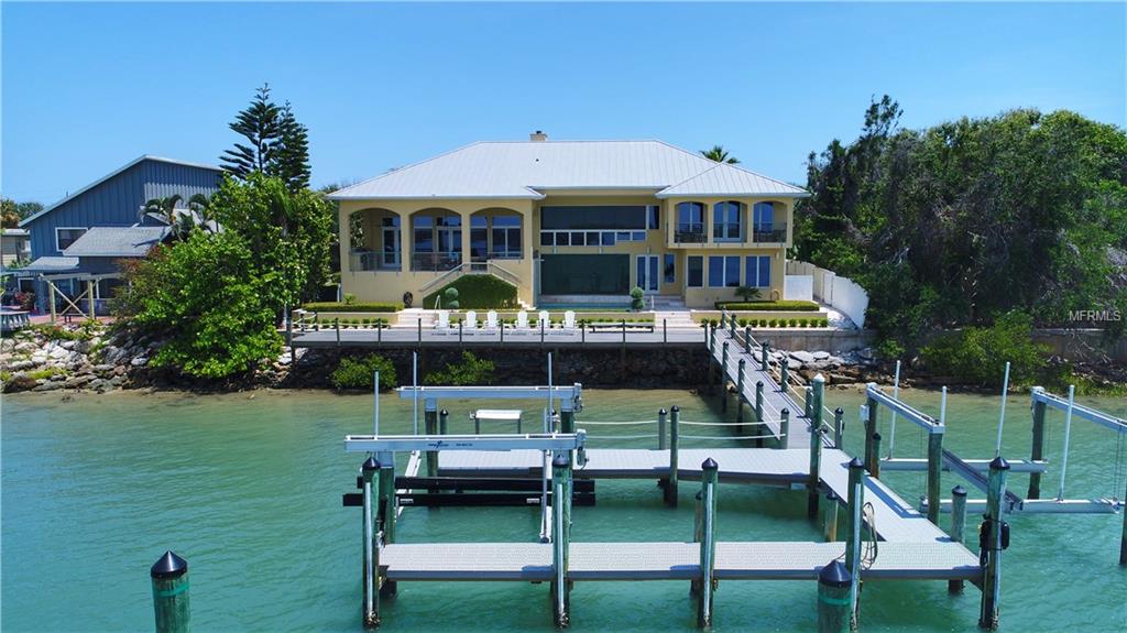 Only a discreet few homes are located along this most desirable part of the island. Quiet street and the homes view all natural landscape over the river. The sunsets are like no other. There are so many attractive features about this home. An easy living floor plan allowing for all your guests to feel the privacy yet come together in all the various gathering places like the family room with soaring ceilings, the pool area with hot tub and large covered outdoor kitchen and the inside kitchen area with wet bar, island and large family gathering by the fireplace. The dock boasts enough space to host a large party as well. Bring your big boats because there is room for a 60 foot yacht, a 16,000 lb lift as well as a 24,000 lb lift. I doubt you could even build a dock like this today with the current restrictions. The master bedroom overlooks the river with it own private balcony. Spacious bedrooms along with an in law suite downstairs make for a comfortable environment for extended family. Large laundry and tons of storage. The view facing west shall remain unspoiled for tons of privacy and the ultimate viewing of the best sunsets nature has to offer. Close to shopping and restaurants make this one of a kind exquisitely built home a pleasure to call home.