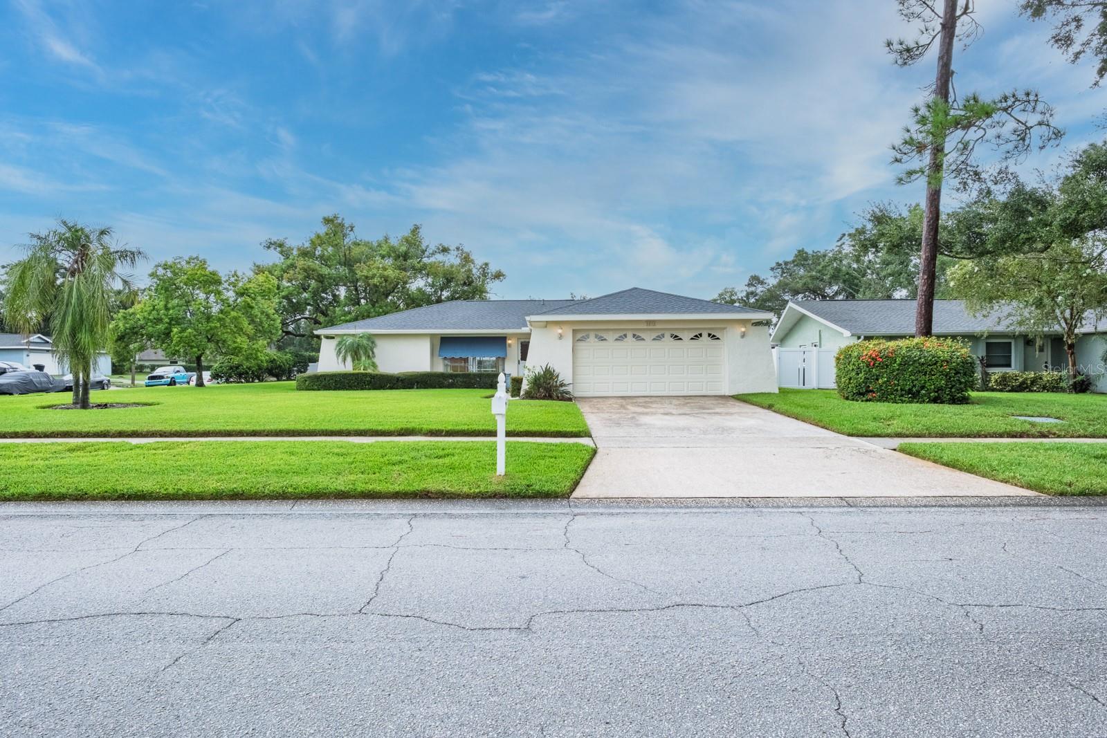 Location! Location! Fabulous Countryside! Meticulously maintained… Pride of ownership abounds! This lovely pool home offers you nearly 1,500 sq. ft. of living with desirable split bedroom floor plan boasting 2 bedrooms, 2 bathrooms and 2 car garage perfectly situated on a corner lot home site. Enter through the front storm door to the open living/dining room combination with sliding glass doors to outdoor lanai. Kitchen boasts plenty of counter space for entertaining, tile backsplash, stainless steel appliances including refrigerator (2019), dishwasher, counter top microwave (2023), ceran top range with tons of natural light through the exterior windows overlooking the fabulous pool. Family room is located next to the kitchen. Extend your living and entertaining outdoors through the sliding glass doors off the family room to the spacious covered lanai, vaulted screen enclosure with fabulous pool. All this overlooking the spacious rear yard with plenty of room for kids or furry babies to play. Primary bedroom is located off the living/dining room area boasting full walk-in closet, ensuite with single vanity and full walk-in shower with glass door. The very large secondary bedroom is located on the opposite side of the home along with the conveniently situated hallway bathroom offering single vanity and tub/shower combination with sliding glass door. Laundry is ideally located inside the home just off the garage door entrance and the seller is generously offering the washer and dryer convey with the home. Additional notable updates include Plantation shutters, AC 2025, Water Heater 2023, Roof 2014, Pool pump 2023, Pool resurfacing 2017, Lanai rescreened 2023, Outdoor lanai ceiling 2023, Sprinkler well pump 2023, Garbage Disposal 2025. This exceptional location is near to all… shopping, restaurants, airports, medical and just a short drive to delightful Downtown Dunedin as well as the powder white sands of the legendary Gulf beaches.