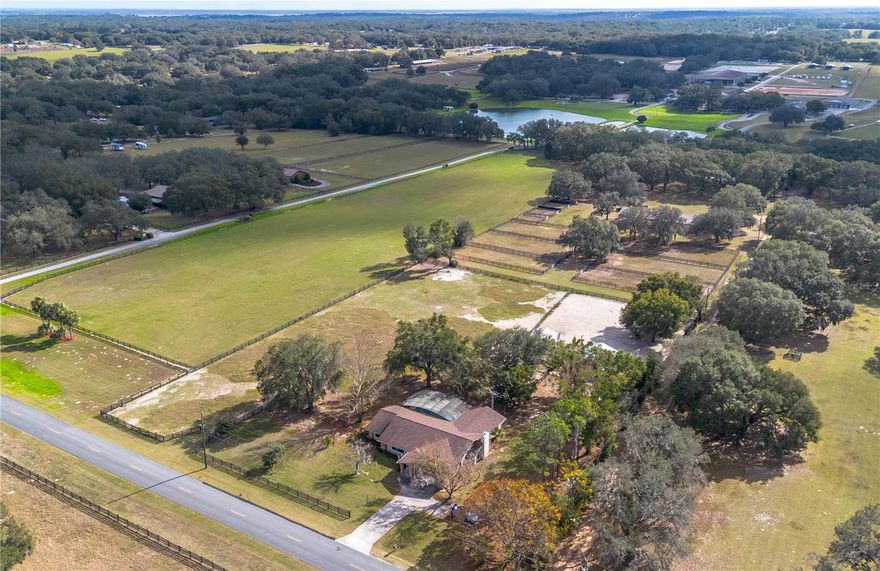 One or more photo(s) has been virtually staged. Set amongst mature oaks, this nearly 3-acre equestrian property in Weirsdale offers a rare blend of peaceful country charm and smart functionality, crafted with the horse enthusiast in mind! The 3-bedroom, 2.5-bath home has been thoughtfully updated with a newer roof as of 2022, a new septic system, and replaced windows in the primary bedroom, living room, and sliding glass doors. Offering over 2,500 sq ft of space, the home opens to vaulted ceilings and abundant natural light, with a thoughtful split-bedroom floor plan that ensures privacy. The spacious living area is anchored by a striking stone fireplace, beam-accented ceilings, and large windows. The kitchen, rich with rustic wood cabinetry and stainless appliances, offers ample prep space and potential for future personalization—an opportunity to make this home uniquely yours. Tile flooring carries through the main areas, while plush new carpet adds comfort to the two guest bedrooms. Both bathrooms have been tastefully renovated, blending modern finishes with timeless style. The primary suite is an inviting space that features a larger layout, a generous walk-in closet, serene views of the surrounding property, and a private en-suite bathroom with dual sinks and a step-in shower. Just beyond the formal dining area, sliding glass doors lead to a fully screened patio with a large in-ground pool, creating an ideal setting for hosting or enjoying the year-round sunshine. Beyond the home, the equestrian facilities are where this property truly shines. A well-designed barn includes four stalls, each equipped with fans and misters for year-round comfort. A 20x20’ run-in shelter mirrors the same attention to equine care, also outfitted with its own fans and misters. The 10x10’ tack and feed room is air-conditioned, perfect for gear, grain, and rider respite alike. There are three fenced paddocks, laid out for efficient rotation and easy access, all enclosed with a mix of board and wire fencing. With optional membership to The Grand Oaks community, you’ll enjoy access to miles of riding trails, multiple arenas, a world-class eventing course, and a vibrant schedule of horse shows and equestrian events. Start your Mondays at the on-site Bistro, a local favorite for riders and guests alike. Bordering the Grand Oaks Resort and located just a short distance from the Florida Equine Center and multiple shopping, dining, event, and entertainment options, this well-rounded property is an ideal blend for someone looking for both convenience and countryside living. Schedule your showing today!