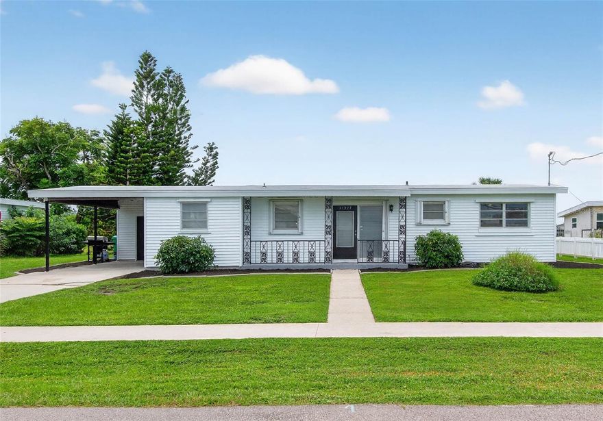 Step inside this thoughtfully renewed 2-bedroom, 1-bathroom home in Port Charlotte, where every detail has been carefully designed for comfort and style. Just beyond the entry, a brand-new drop station provides a convenient space for organizing daily essentials. Updates include fresh drywall, crisp paint, upgraded baseboards, and new closet doors, creating a bright and welcoming interior. The original terrazzo flooring, still in excellent condition, adds a touch of classic charm. Additionally, new lighting and new remote control ceiling fans have been added to all rooms. At the heart of the home is the stunning open kitchen, crafted with a chef’s eye. It showcases an oversized butcher block island, leather-finished granite countertops, a stylish backsplash, all-new cabinetry with upgraded hardware, stainless appliances, and a deep single-basin sink perfectly placed beneath a window with a front-yard view. The layout also offers indoor washer/dryer hookups for added convenience. Natural light streams through the expansive windows, all dressed with blinds, revealing panoramic lake views from nearly every room. Toward the back, a Sun Room with dramatic vaulted wood ceilings and exposed beams provides the perfect spot to unwind while overlooking the tranquil landscape. The home also offers a screen lanai and brand new rod iron fenced backyard with plenty of green space for family or pets. Additional highlights include a new composition roll roof (2022), new water heater (2023), accordion hurricane shutters, a covered carport with an attached storage room, and an extra shed for even more storage. Just ¼ mile from McGuire Park, offering splash pads, playgrounds, and basketball courts, this home is also centrally located for quick access to Port Charlotte, Punta Gorda, Englewood, Boca Grande, and I-75.