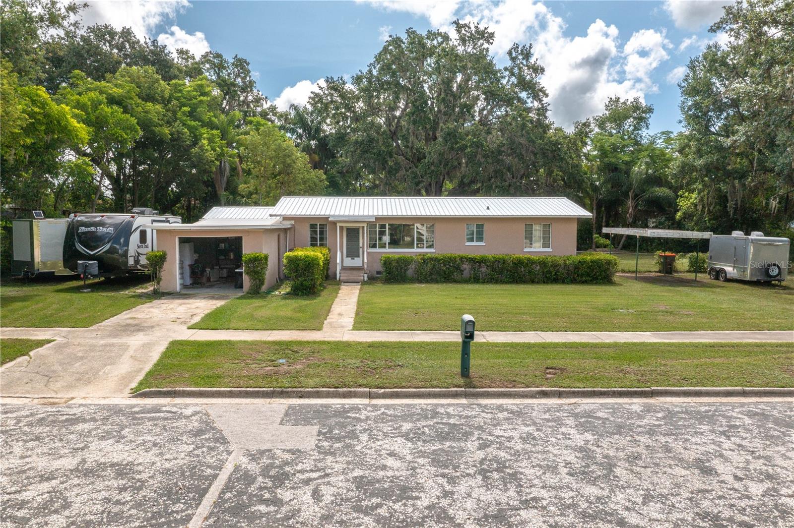 PRICE REDUCED! Ideal opportunity to make this 3-bedroom, 2-bathroom block home your own! This home is full of potential and perfectly located within walking distance to schools, the football stadium, and downtown Wauchula/Main Street. Situated on a spacious HALF-ACRE lot, the property features a private, tree-lined backyard ideal for relaxing or entertaining. A new metal roof was installed in 2024, offering peace of mind for years to come. Inside, you'll find original hardwood floors beneath the existing vinyl—just waiting to be uncovered and restored. The home includes a versatile 10x20 air-conditioned Florida room with a gorgeous wood ceiling, perfect for a home office, playroom, or family room. While the home does need some TLC, it offers a fantastic opportunity to customize and make it your own. Schedule your showing today!