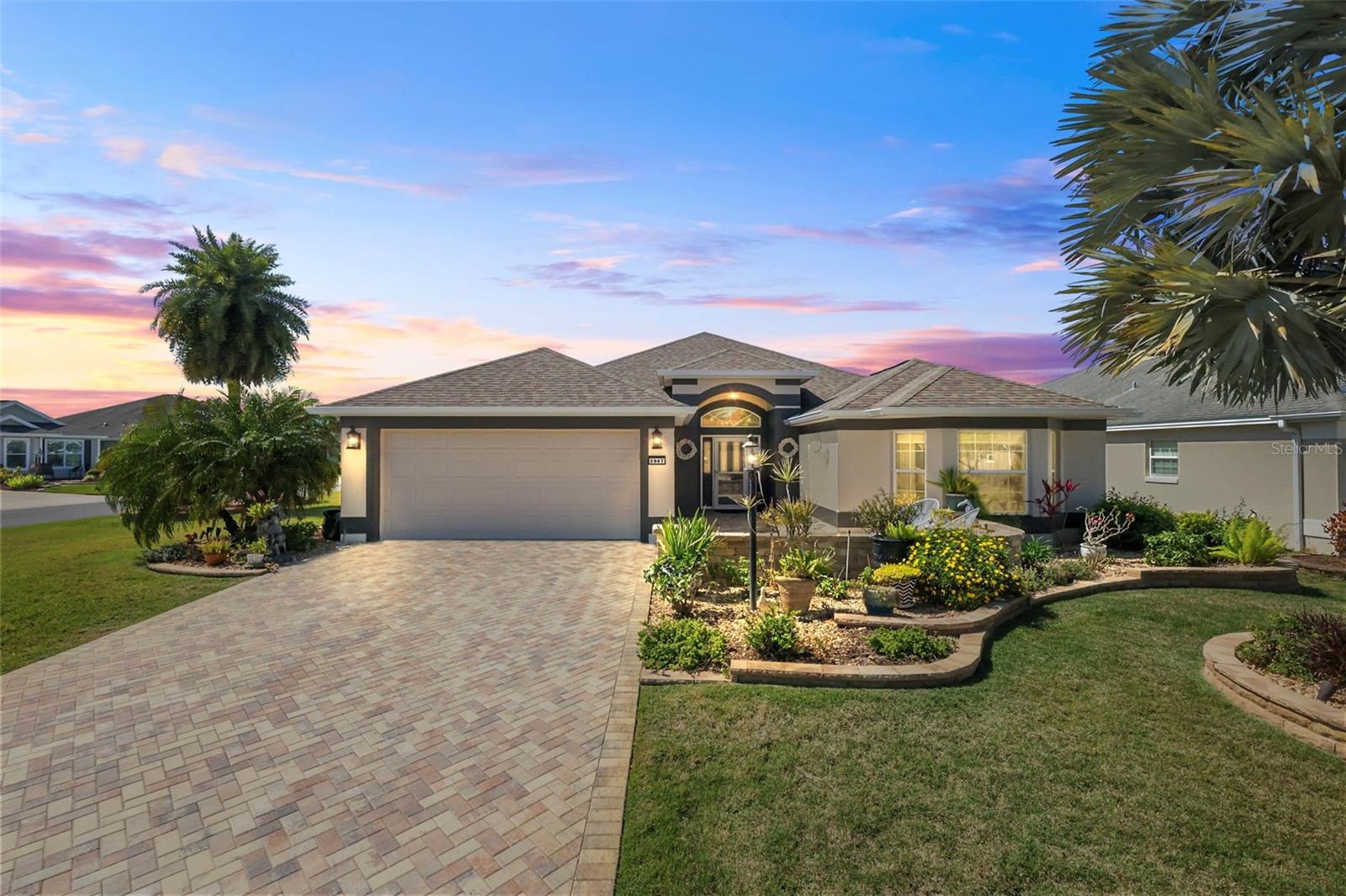 ABSOLUTELY STUNNING, BEAUTIFULLY RENOVATED, EXPANDED 3/2 BLOCK and STUCCO LANTANA with IMMENSE 442sf CLIMATE-CONTROLLED FLORIDA ROOM, and OVERSIZED, EXTRA DEEP, 544sf garage with room for TWO CARS + GOLF CART, on a LARGE CORNER LOT, CONVENIENTLY NESTLED between Lake Sumter Landing and Brownwood Paddock Squares in the HIGHLY DESIRABLE Village of Sanibel! As you approach this INCREDIBLE home, you can’t help but notice the beautiful BRICK-PAVER driveway, TIERED landscaping, and SPACIOUS FRONT PATIO—ideal for RELAXING in the Florida sunshine or ENJOYING fun-filled OUTDOOR ENTERTAINING with friends! A double side-lit, leaded-glass door with large transom window welcomes you in to the bright SPACIOUS foyer with a convenient ENTRY CLOSET. Throughout the home, you will discover LUXURY VINYL PLANK FLOORS, HIGH CEILINGS, 5 1/4” BASEBOARDS, and newly PAINTED interior—all creating a fresh and modern feel. The MAGNIFICENTLY RENOVATED KITCHEN boasts an ENORMOUS center ISLAND with DOUBLE-SIDED cabinets and a THIRD SIDE of DRAWERS, MODERN VEINED-QUARTZ countertops, WHITE CABINETRY with PULL-OUT shelves, DOUBLE built-in PANTRY, STAINLESS appliances, UNDER COUNTER lighting, reverse-osmosis water-filtration, and an ADJACENT DINETTE area that is currently furnished as a COZY sitting space. Two newly added SOLAR TUBES add an ABUNDANCE of NATURAL LIGHT to the kitchen, living, and dining rooms. From the main living areas, 12' STACKABLE sliding glass doors lead you into an IMMENSE 442sf CLIMATE-CONTROLLED FLORIDA ROOM. This FABULOUS BONUS AREA features a MINI-SPLIT, 10' HIGH VAULTED ceilings, TILE floors, motorized window shades, three ceiling fans, full panel sliding glass doors, exterior French doors, and PRIVACY landscaping. In addition to this AMAZING room, there’s also an ADJACENT 12’ x13’ SCREENED LANAI with TILED floors and an exterior BRICK-PAVER grilling area. The luxurious primary bedroom features VAULTED ceilings and a CUSTOMIZED WALK-IN closet. Its en-suite bathroom boasts TILE flooring, rich WOOD cabinetry, GRANITE countertops, DOUBLE sinks, TILED ROMAN STYLE WALK-IN shower, built-in LINEN closet, make-up vanity, and separate water closet. Two additional bedrooms and a second bathroom are conveniently located near the front of the home ensuring plenty of PRIVACY for guests or home office. The second bedroom boasts a lovely TRAY ceiling, large BAY WINDOW, and a built-in closet. Bedroom three features a VAULTED ceiling and built-in closet. The second bathroom offers TILED floors, a rich WOOD vanity with GRANITE countertop, TILED tub and shower combination, and a hallway LINEN closet. A generous INTERIOR laundry room features TILE floors and a utility sink. The OVERSIZED 544sf EXTRA DEEP garage with room for TWO CARS + GOLF CART boasts EPOXIED floors and pull-down stairs with attic access for additional storage. DON’T MISS YOUR OPPORTUNITY TO OWN THIS SPECTACULAR HOME! The Village of Sanibel is ideally located between Lake Sumter Landing and Brownwood Paddock Squares; close to Sanibel and Captiva Pool and Recreation Centers; Bonifay, Havana, and Belle Glade Golf and Country Clubs; Roosevelt, Truman, Volusia, and Okeechobee Golf Courses; Sarasota Golf Academy and Practice Center; Colony Shopping Plaza; and 466A with an abundance of shopping, restaurants, banks, medical, and more! PLEASE WATCH OUR WALKTHROUGH VIDEO OF THIS EXCEPTIONAL HOME IN A FABULOUS LOCATION and call today to schedule your Private Showing or Virtual Tour!