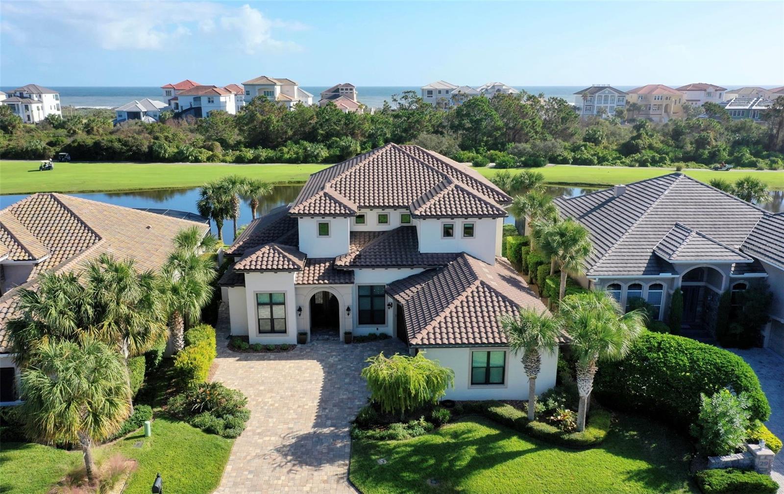 Experience luxury coastal living in this stunning Arthur Rutenberg estate, offering 4,320 square feet of indoor living space in the prestigious gated community of Ocean Hammock. Perfectly positioned on the 6th hole of the Hammock Beach Ocean Golf Course, this home offers a breathtaking golf course and wooded preserve views, with a walking path at the end of the cul-de-sac leading to miles of pristine beaches.
Designed with impeccable craftsmanship, the stunning iron-arched doors welcome you into a home that seamlessly blends elegance and functionality. The expansive glass sliders, including a 90-degree disappearing corner door, create a seamless flow between indoor and outdoor spaces. Step into your private outdoor oasis, featuring a heated saltwater pool, spa, summer kitchen, and a cozy fireplace—ideal for entertaining or unwinding.
The chef’s kitchen is a standout, featuring a central island, top-tier smart appliances, and a walk-in butler’s pantry with a dedicated prep area and a second built-in oven. The spacious dining room includes a wet bar, perfect for hosting and special gatherings.
The primary suite on the main floor is a true retreat, offering custom-designed closets and a spa-inspired ensuite with a dual walk-in shower, soaking tub, and elegant dual sinks. A built-in sound system enhances the home’s ambiance, allowing you to enjoy music throughout.
A highly sought-after feature in Florida homes, this residence boasts exceptional storage throughout, with custom solid-core shelving in every closet. The oversized laundry room is a standout space—perfect for those who love crafts and hobbies or need a functional home office.
Upstairs, the club room with a wet bar opens to a covered balcony with ocean breezes, soothing waves, and views of Space Coast rocket launches. Three additional ensuite bedrooms, one easily convertible into a study, complete the upper level.
This home offers unparalleled access to golf, boating, and luxury coastal amenities located near highly sought-after private clubs, including Hammock Beach Resort, Hammock Dunes Club, and the world-class Hammock Beach Marina.
Discover refined coastal living in this exceptional estate.