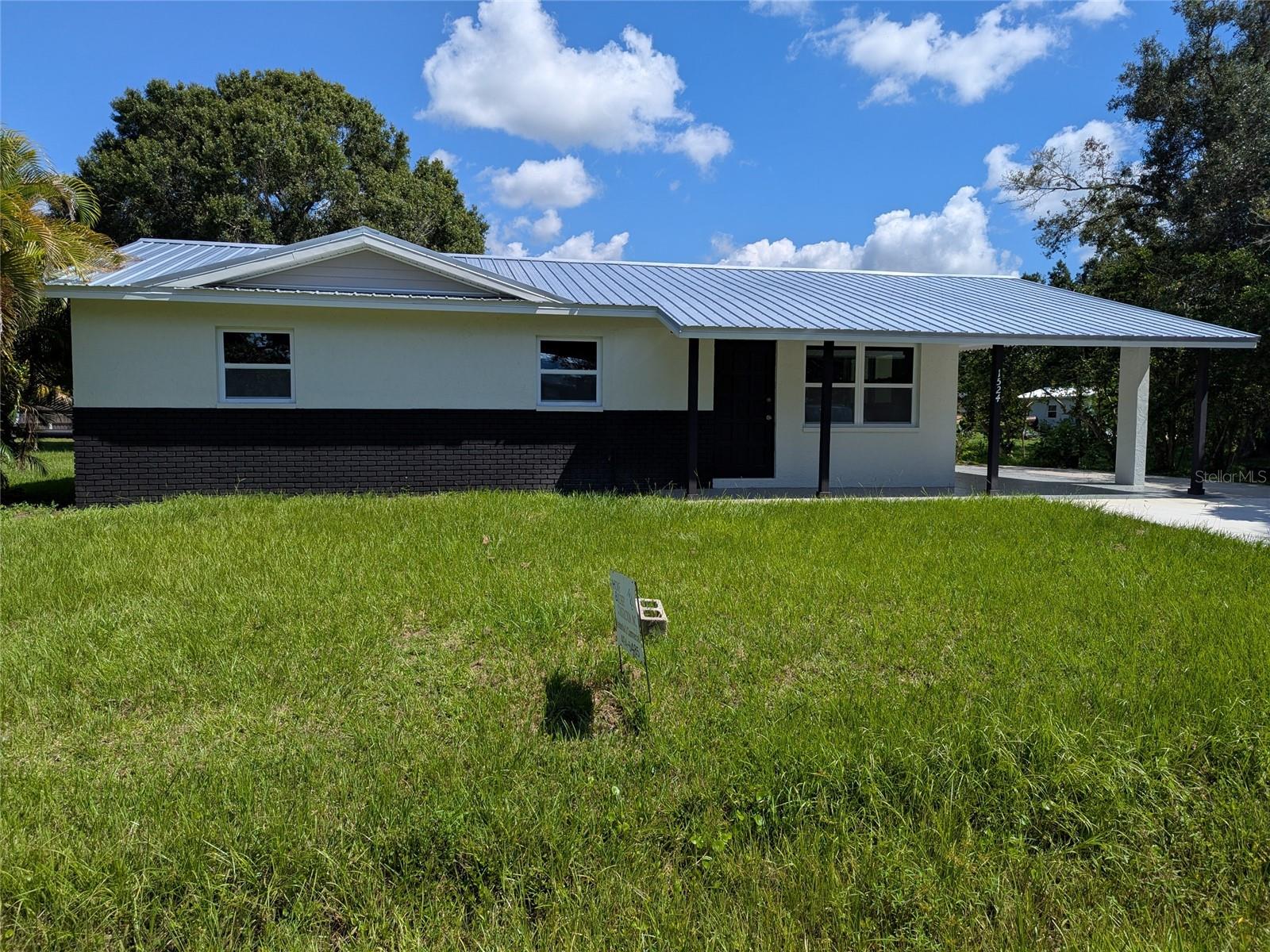 Look at this brand new home ( even tho built originally in 1974) because it is NEW top to Bottom. NEW Metal Roof, NEW central air and heat ( with all new duct work) , NEW kitchen including Stove, Fridge and Dishwasher. New Flooring thru out, all new lights and fixtures, NEW impact windows, New water lines and plumbing. The bathroom is updated with new vanity and flooring, lighting and fixtures. This home is as MOVE IN READY as you can get. It's just beautiful and PROFESSIONALLY renovated by Lic. Contractor. The indoor Laundry room gives you lots of room for adding additional storage cabinets or counters. The front covered porch and the carport have new specialty decorative concrete flooring. In the back of the home is a 12x20 metal storage shed that provides you with electric and flooring. The rear patio was newly covered with concrete and leveled. Nice private bar b que area in the back. The back yard is large giving room for playing games or for your pets. Seller had a boundary survey done and currently the stakes are still visible. make your appointment to view this charmer !!