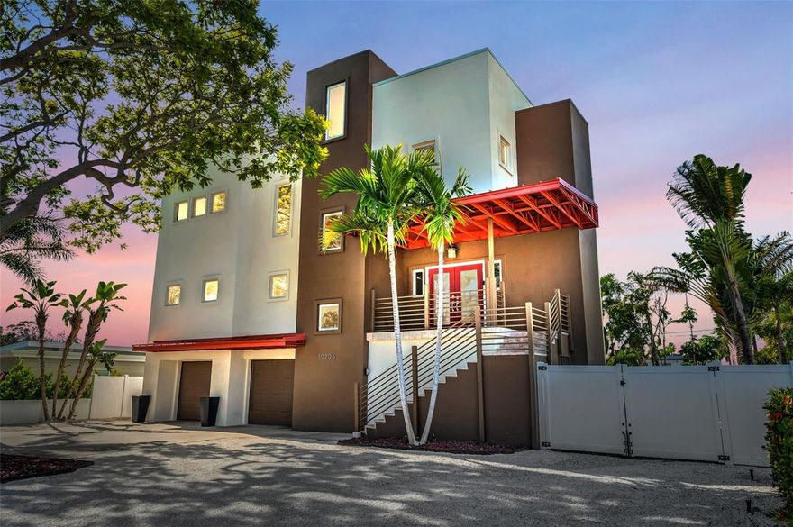 A masterpiece of modern coastal design, this Treasure Island residence blends architectural elegance, luxurious finishes, and effortless livability. Built with superior ICF construction for exceptional strength and energy efficiency, this home welcomes you with soaring 21-foot ceilings and large picture windows that fill the home with natural light. The open-concept great room creates an immediate sense of grandeur, flowing into an impressive chef’s kitchen designed for both beauty and performance. Outfitted with professional-grade stainless steel counters, a commercial gas range, open shelving, a spacious walk-in pantry, and a wraparound island perfect for entertaining, the kitchen is the heart of the home. The primary suite is a private sanctuary featuring two custom closets, a spa-inspired bath with dual vanities, a jetted soaking tub, and a walk-in stone shower. Hurricane impact rated sliding doors lead from the suite to an expansive balcony overlooking the lush tropical landscape, ideal for morning coffee or evening sunsets. Upstairs, two oversized guest bedrooms each feature walk-in closets and share a sleek double-vanity bath, while a versatile loft offers space for a home office, media room, gym or playroom and more. In addition to the balconies on every living level, a resurfaced rooftop terrace captures sweeping sunrise and sunset views across the Gulf and Intracoastal. Outside, the resort-style backyard showcases new turf, lush tropical landscaping, and a sparkling pool with an integrated spa for the ultimate retreat. A deep four-car garage offers abundant storage for vehicles, golf carts, and beach gear. Elevated construction, assumable flood insurance, and hurricane impact-rated windows and doors provide peace of mind, while 2023 HVAC systems, fresh interior paint, new luxury flooring, and updated landscaping ensure move-in perfection. With 5,481 square feet under roof, this home offers an extraordinary level of space and livability, all just a short walk or golf cart ride to Treasure Bay’s tennis and pickleball courts, playground, waterfront park, and the pristine sands of Treasure Island Beach and boardwalk. This is a truly beautiful home you won’t want to miss.