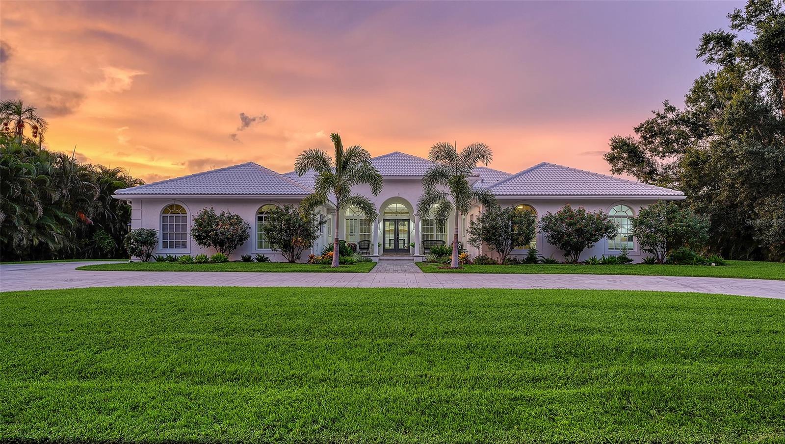 Tucked within the prestigious, gated enclave of Beneva Oaks, where centuries-old live oaks line meandering streets, this masterfully renovated home on a ½ acre lot offers incredible 2025 updates and a wonderful 4-bedroom, 3.5-bath, 1-story floor plan providing both grandeur and comfort across the expansive space. A circular drive framed by lush landscaping leads to the elegant entry of this modern residence, where refined upgrades blend seamlessly with timeless architectural features. Inside, travertine floors flow through the main living areas, while new designer carpet enhances the comfort of the bedrooms. The heart of the home is the extraordinary new eat-in kitchen featuring gleaming quartz countertops, crisp white wood cabinetry, stainless appliances including an induction cooktop, wide plank porcelain tile floor, and a custom tile backsplash. Accents like gold hardware, designer lighting, crown molding, and wide baseboards add the feel of luxury, while four sets of French doors connect the interior seamlessly with the lush exterior surroundings. An elegant dual-sided wood-burning fireplace with brick and tile surround and quartz and travertine hearths anchors the living and sitting areas, creating inviting spaces for conversation or quiet moments. With multiple entertaining areas designed for both intimate gatherings, grand-scale events or even a game of pool, the home's layout flows effortlessly from indoors to the screened lanai with paver deck, where a heated pool enhanced by Iconic Pools with sparkling new glass tile surface invites year-round enjoyment. The spacious primary suite, is a sanctuary unto itself, offering three walk-in closets with custom closet systems, and an extraordinary spa-inspired bath with bespoke tile work, frameless glass shower, gold fixtures, and a quartz-topped dual-sink vanity that exudes luxury. Two additional guest bedrooms enjoy new carpet, large closets, and generous natural light, while the newly redesigned guest bath impresses with design-forward flooring, quartz dual-sink vanity, and clean, modern finishes. The 4th bedroom can also be used as in-law suite, enjoying its own private French door entry and full bath with walk-in shower. The office with a custom built-in loft, closet, and a front facing window is ideal as a workspace, study, play, or creative escape. A chic updated powder bath adds further convenience. The thoughtfully designed laundry room features quartz countertops, utility sink, abundant cabinetry, and front-load GE Whirlpool washer/dryer. The oversized 2-car garage and beautifully landscaped grounds complete this exceptional property in one of Sarasota’s most serene and sought-after neighborhoods. Located in a top rated school district, X flood zone and within close proximity to Sarasota's dining, shopping, culture, and the pristine Gulf of Mexico beaches, this exceptional property offers an unparalleled combination of design and craftsmanship in one of Sarasota’s best-kept secret neighborhoods, presenting a rare opportunity to experience refined Florida living at its finest!