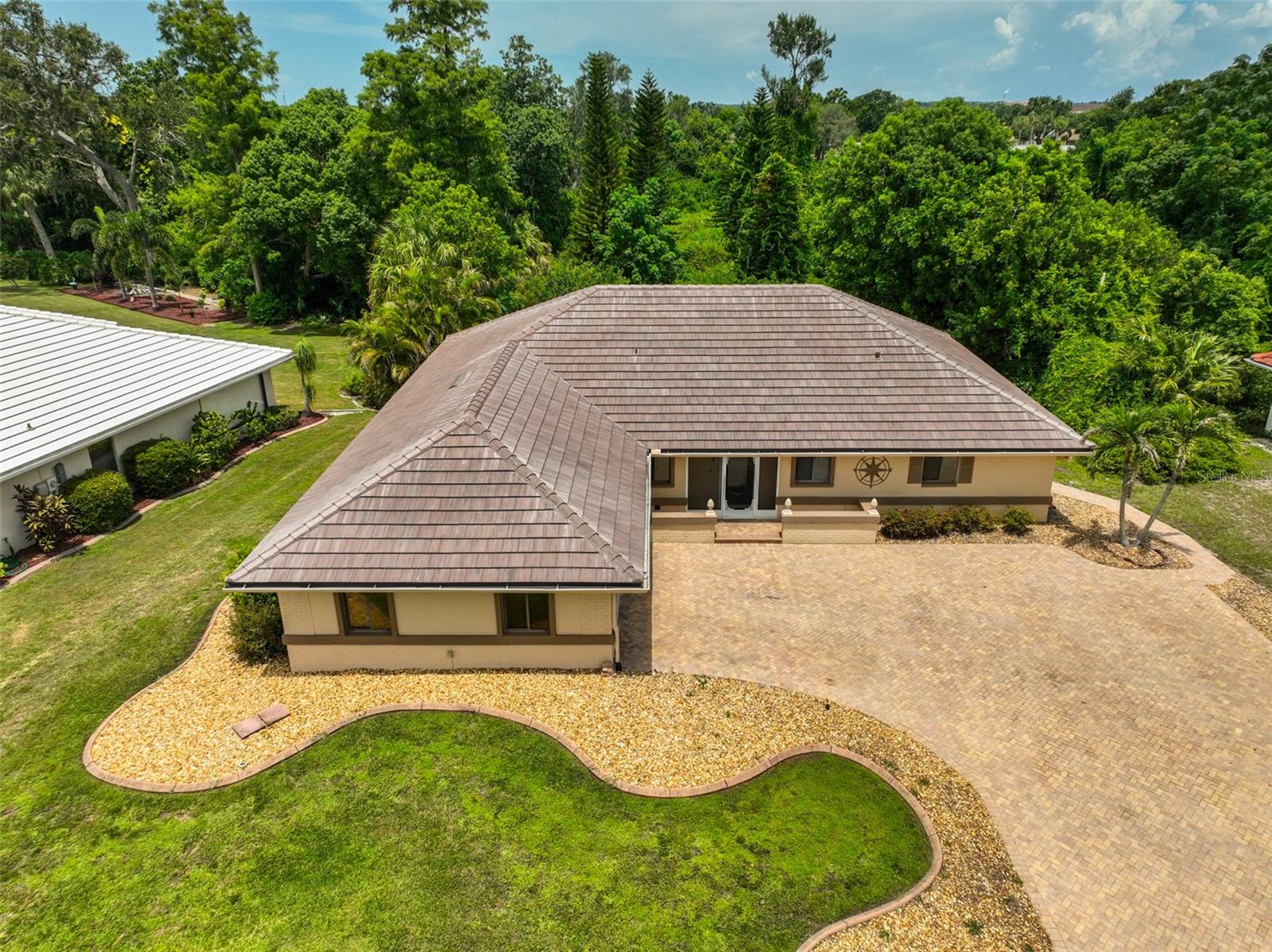 One or more photo(s) has been virtually staged. **Watch 3D Tour Above** Beautifully UPDATED, PRIVATE, Stylish, and MOVE-IN READY — a NATURE LOVER’S DREAM…Your Secluded Retreat Awaits. Neighborhood HOA is ONLY $50 annually. This spacious ISLANDER model home has been lovingly MAINTAINED and updated from floor to ceiling with no “honey do” items here. Major upgrades, such as a BRAND-NEW TILE ROOF (warranty will be transferred to buyers) and a ONE YEAR PAID HOME WARRANTY, offers peace of mind for years to come. Tucked away in a peaceful setting, this beautifully updated home offers the perfect blend of modern comfort and natural serenity. It is located on an EXTREMELY DEEP LOT, which backs up to conservation land and is surrounded by MATURE LANDSCAPING. This ensures total backyard PRIVACY, frequented by birds, butterflies, and local wildlife—a true escape from the everyday. A spacious, PAVED DRIVEWAY and PARKING PAD welcomes you home with plenty of room for multiple vehicles, guest parking, or even recreational toys. A matching PAVERED WALK PATH surrounds the entire home to give a sophisticated and cohesive feel to the yard. Step inside and be captivated by the SOARING CATHEDRAL CEILINGS and a SPACIOUS GREAT ROOM filled with natural light. Enjoy breathtaking floor-to-ceiling views from the main living areas that overlook your very own SECLUDED, WOODED BACKYARD. The interior boasts modern ceramic TILE FLOORING THROUGHOUT the entire home, creating a sleek, cohesive look that’s both stylish and peaceful. The updated kitchen is a true showstopper—featuring NEWER STAINLESS-STEEL APPLIANCES (including an oven that can be used as a single or dual unit), QUARTZ countertops, CUSTOM CHERRY cabinets w/PULL OUT drawers and NEW LIGHTING. It’s designed for both everyday living and entertaining. A large FAMILY ROOM allows for easy entertaining or separate activities from the great room. Primary bedroom SUITE boasts a full VIEW OF THE BACKYARD in total PRIVACY! With a WALK-IN CLOSET and ENSUITE BATH, you will enjoy complete privacy. Bathrooms have been tastefully renovated with modern fixtures and finishes. Next to the LAUNDRY ROOM, there is even an area for an OFFICE, CRAFT ROOM or additional storage. The garage has a NEW HURRICANE/IMPACT rated garage door, sliding screens, is a good size with LOTS OF STORAGE CABINETS and a work shop table for puttering. But the SCREENED LANAI and the CUSTOM PAVERED OPEN-AIR BACK PATIO is probably where you will spend most of your time RELAXING, LISTENING TO BIRDS and entertaining friends. Whether you’re sipping coffee in the morning or hosting guests in the evening, the setting offers unmatched tranquility and privacy. The OPEN-AIR PATIO is already equipped with ELECTRIC LINES. This home is perfect for those who value quality updates, functional design, and a peaceful connection to nature—all while being just minutes from local conveniences. Schedule your private showing today and fall in love with everything this unique property has to offer. Sun City Center has 3 beautiful clubhouses, hundreds of social and sports clubs, dance, theater, an arts and crafts building, state-of-the-art medical facilities, shopping, endless entertainment & resources all accessible by golf cart. Remember, one owner must be 55+, but adults over 18 may reside in the home. TILE ROOF – 2025; HVAC (with updated electrical panel) – 2019; WATER HEATER – 2016; REPLUMBED