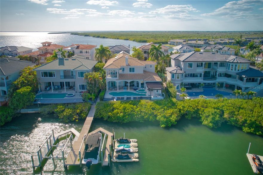 Tucked behind the gates in the exclusive Reserve at Old Tampa Bay, this exceptional waterfront estate offers the ultimate blend of privacy, luxury, and modern design. Set on open water with breathtaking views, the home features an expansive open floor plan designed for both everyday living and effortless entertaining.

Inside, you’ll find four spacious bedrooms, each with its own en-suite bathroom, along with a dedicated office and a convenient first-floor guest suite. The interior has been completely updated with sleek, modern finishes, highlighted by beautiful hardwood flooring throughout and a dramatic floor-to-ceiling stone fireplace anchoring the main living space.

The custom chef’s kitchen is a showpiece, boasting quartz countertops, stainless steel appliances, large center island, and a generous walk-in pantry. Seamless indoor-outdoor living is achieved through large retractable sliders that open fully to the pool and deck area.

Upstairs, the luxurious primary suite offers a private balcony overlooking the water, along with a spa-like bathroom featuring a massive walk-in shower, soaking tub, dual vanities, and an oversized walk-in closet.

Step outside to your personal resort: a sparkling pool with spa, a built-in cold plunge adjacent to a sauna bath, and a sprawling outdoor deck complete with a stone fireplace, covered seating, and a fully equipped outdoor kitchen. For boating enthusiasts, the private dock with boat lift provides easy access to open water—truly a boater’s paradise.

Move-in ready and impeccably updated, this home delivers unmatched comfort, style, and waterfront serenity in one of the area’s most sought-after communities.