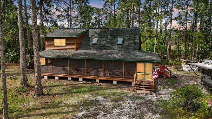 Ready to escape the hustle and bustle of city life and retreat to your own personal wooded paradise? Look no further! Situated on two acres, this property will transport you to the mountains while keeping you close enough enjoy everything Central Florida living has to offer including easy access to the 429! Bring your toys and rods because with RV parking, a pond, a gun range, and two acres to let your imagination run wild, you'll be hard pressed to duplicate all that this property has to offer. Upon pulling in the solar powered gate, your eye will immediately be drawn to the log cabin home with a screened in wrap around porch. Imagine sipping your morning coffee or evening cocktail while letting the sounds and sights of nature relax you. Upon entering the home, the vaulted ceiling, open concept, flood of natural sunlight, and spacious living area will have you excited to host large gatherings or enjoy the solitude without feeling cramped. The first floor also offers two spacious bedrooms and a full bathroom. The upstairs is a dedicated owners retreat complete with office area, bedroom, walk in closet, and full bath that offers both privacy and space away from the main living areas. Outside you'll be delighted to find a 20 x 20, 400sqft, well-kept shed perfect for tools, toys, and equipment. Looking to keep in-laws close? The second acre is able to be built on as well! Have peace of mind knowing this home has been well loved. Updates include: whole home replumbing (2025), fresh exterior paint (2025), new outdoor carpet on wrap around porch (2025), new screens and doors on porch (2025), all new insulation and vapor barrier in crawl space (2025), a newer roof, reverse osmosis well filtration, shed (2017), washer and dryer (2018), carpet (2019), HVAC (2019), refrigerator (2022), built-in oven (2017), disposal (2023), septic lift station pump (2023), cooktop (2023), new ceiling fans in the master and porch, and LVP flooring in the kitchen and dining area (2024). With hurricanes always top of mind, you can keep your cool knowing your new home is wired for a whole home generator. If all of this wasn't enough, the HOA also includes access to a park and playground off Wildflower Way and a private boat ramp to Lake Norris. The only thing this property is missing is you!