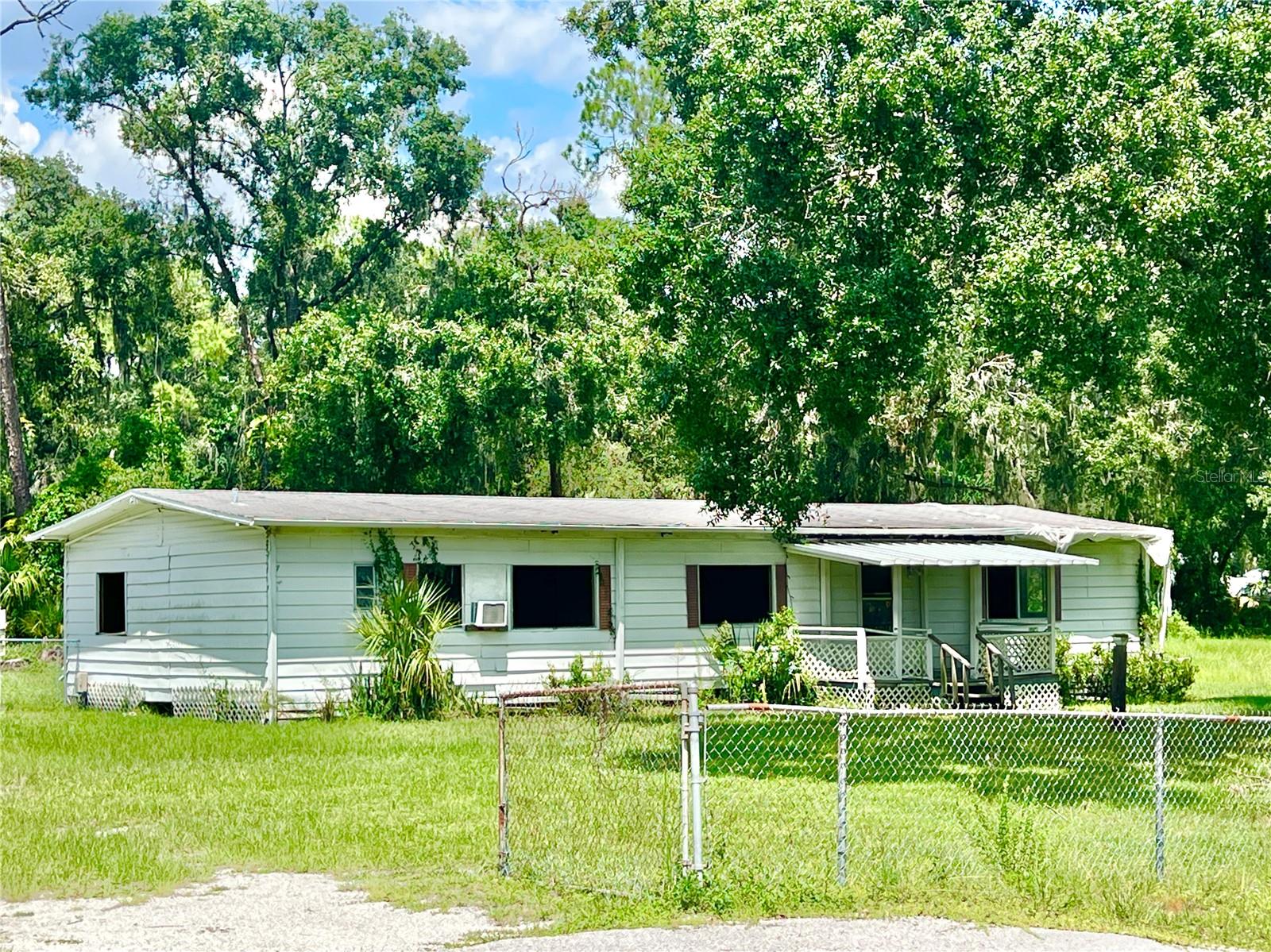 This is an ideal property AND LOCATION to BUILD YOUR OWN DREAM HOME! There's NO HOA or CDD and it's .86 of an acre! The community is comprised of large properties, assuring plenty of space between homes in a serene and quiet neighborhood. There are single family homes, as well as modular homes and manufactured homes. The manufactured home on this property was damaged during Hurricane Milton, and the occupant had to move out. The home has been cleared out, and could possibly be repaired if the buyer has resources. The electricity has been turned off by the seller for safety reasons. The septic is near the SW corner of the home, and the white well house is located on the backside of the property. There is a pond on the East side of the property which could accommodate a relaxing water feature with some creativity....OR the pond could be filled in, giving more yard space. There are four 60-foot steel beams currently under the base of the home which can be utilized for a new home. The property is zoned RSC-2 which means only 2 homes per acre, and since there's not quite an acre, it can only allow one home. The dimensions of the property are 246' x 162'. See photo captions for more details about the property. AND WHAT A GREAT LOCATION TOO! This community is zoned for TOP-RATED SCHOOLS, and is close to The Brunchery, The Landing Bar & Grill, and several other retail/professional businesses. A mile north on the corner of Lithia Pinecrest & Bloomingdale Ave, there is a plethora of shopping, Publix, Sprouts, JF Kicks Bar & Grill, Bullfrog Brewery, Chili's, Panera, Crunch Fitness, and so many other great establishments....AND a Whole Foods is currently being built at that corner too. Within 30-45 minutes of many state parks, MacDill Air Force Base, Downtown Tampa, Tampa Int'l Airport, Busch Gardens, and only an hour from TOP-RATED BEACHES and the DISNEY/Orlando area!